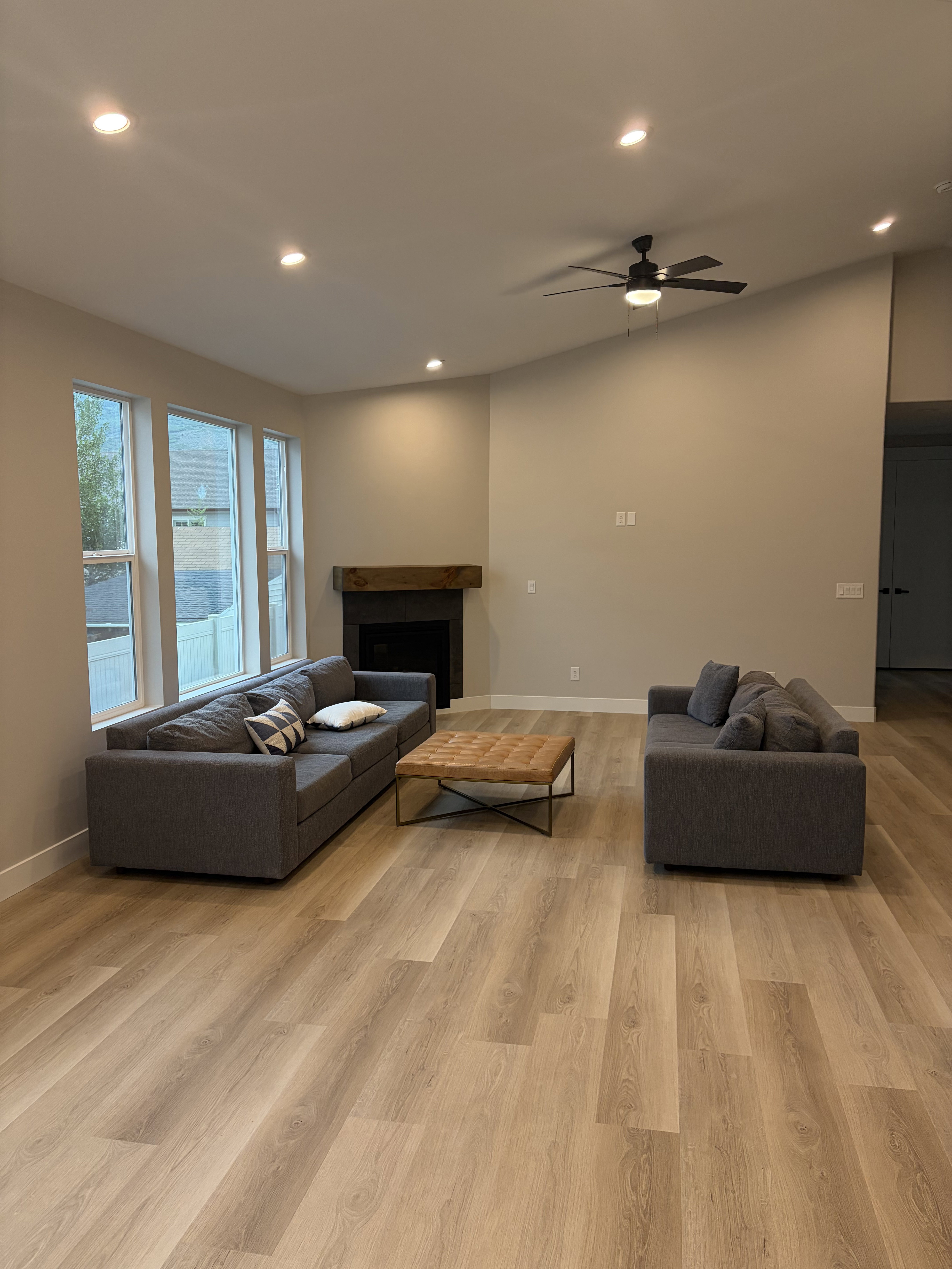 Spacious living area featuring wood-finish flooring, recessed lighting, and a modern ceiling fan