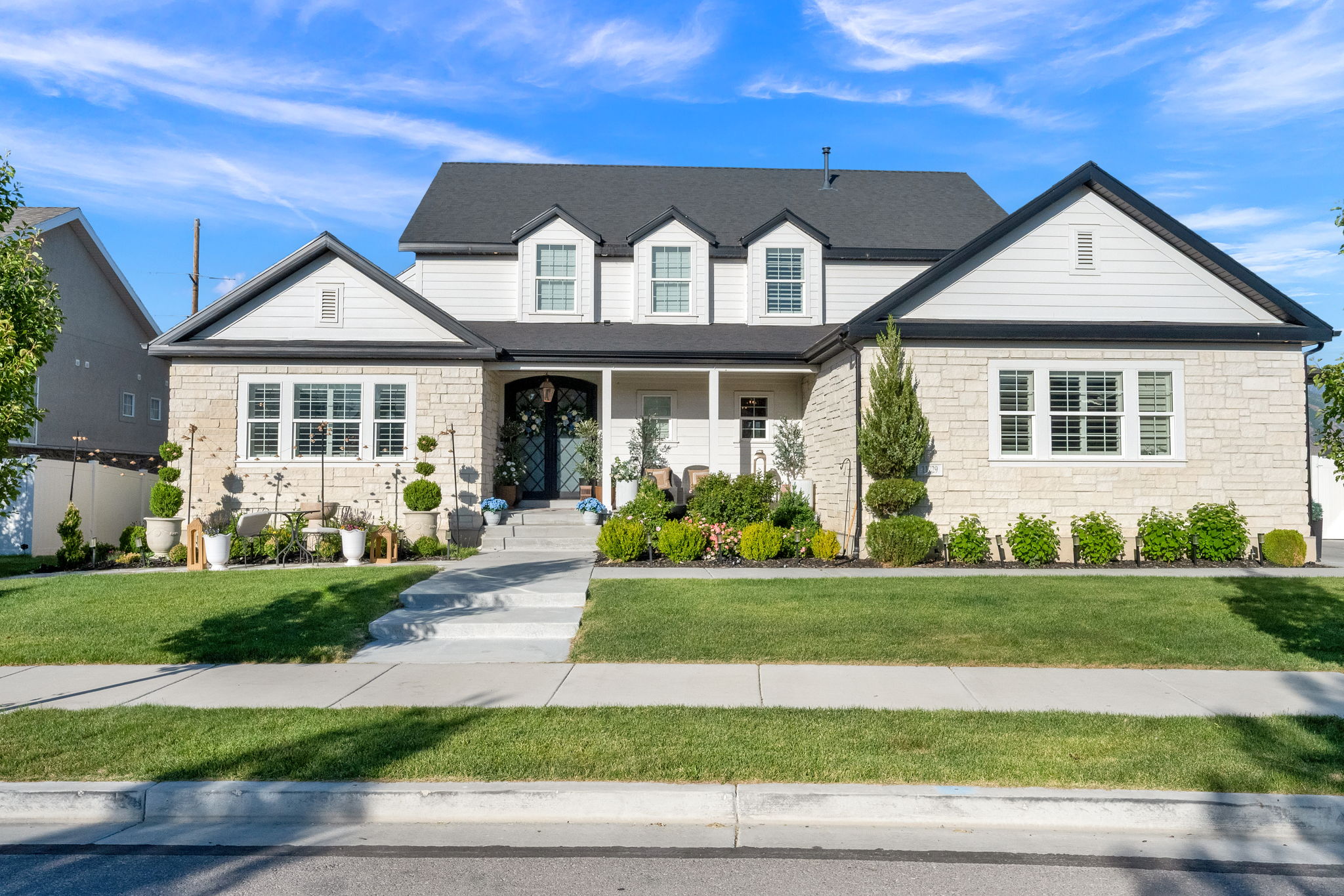 Stone and siding exterior with a dark roof and white trim