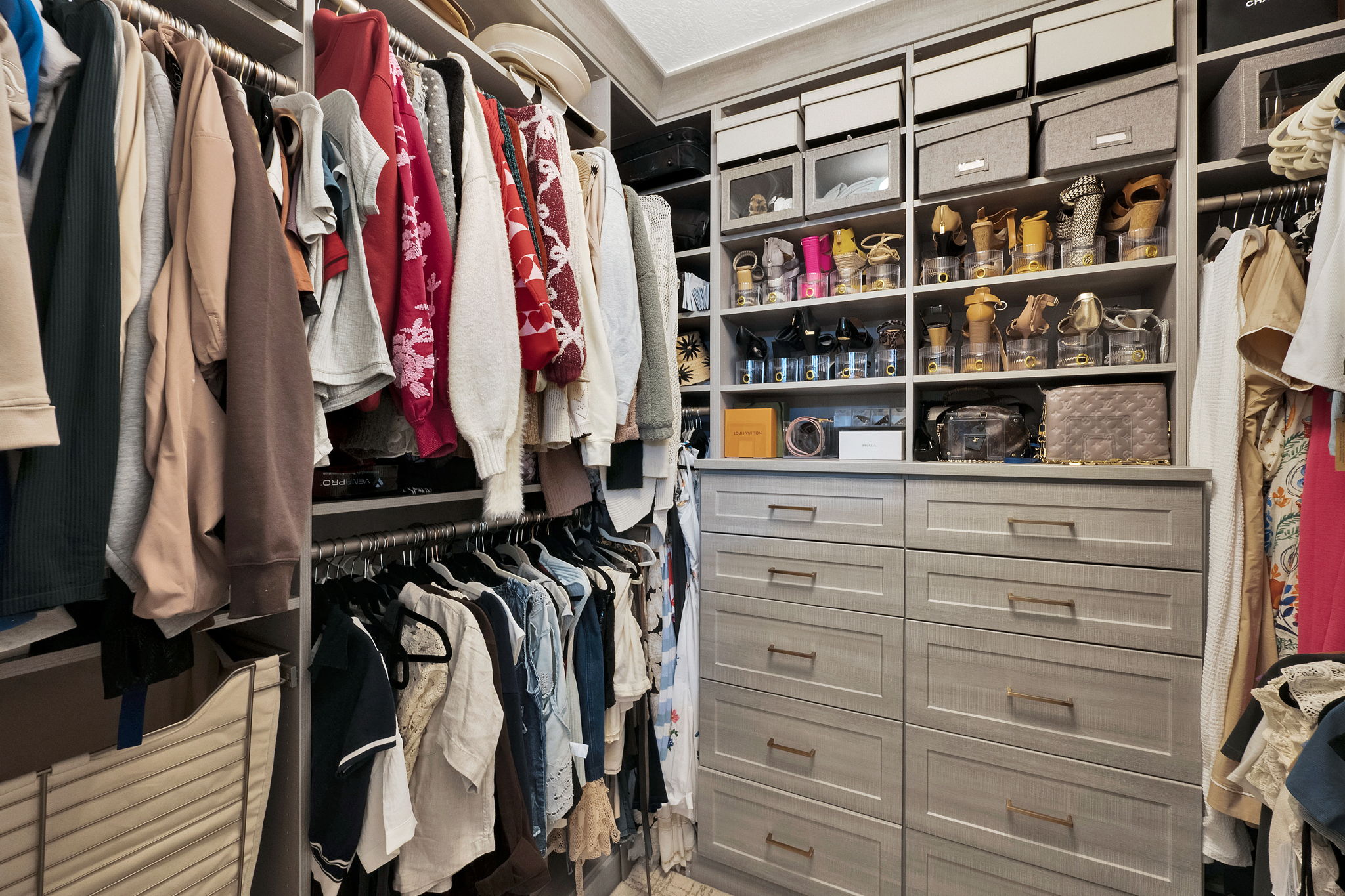 Custom closet organization system featuring light gray cabinetry