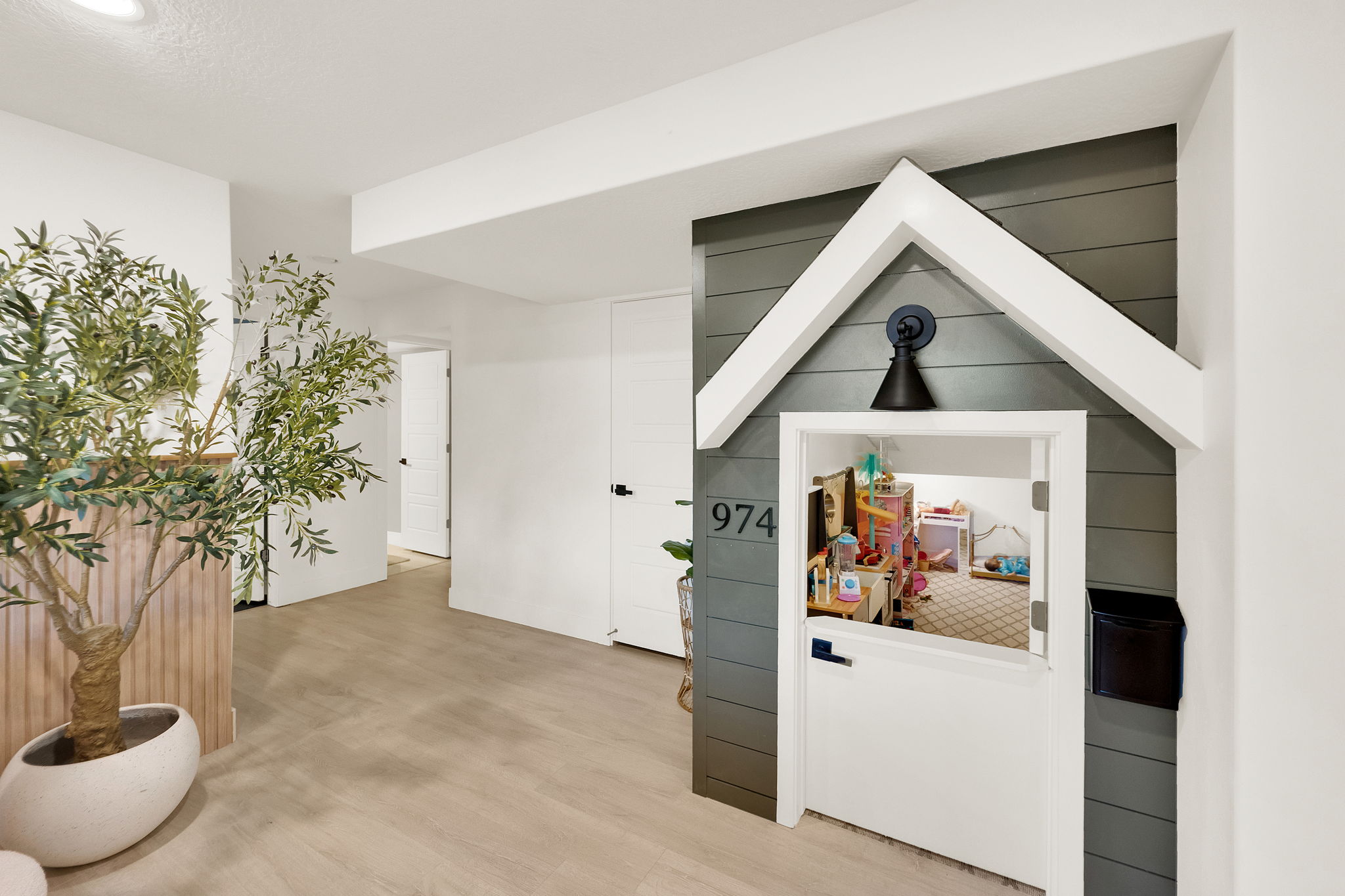 Custom built-in structure featuring a miniature house design with a functional door, decorative house numbers, and an overhead light fixture