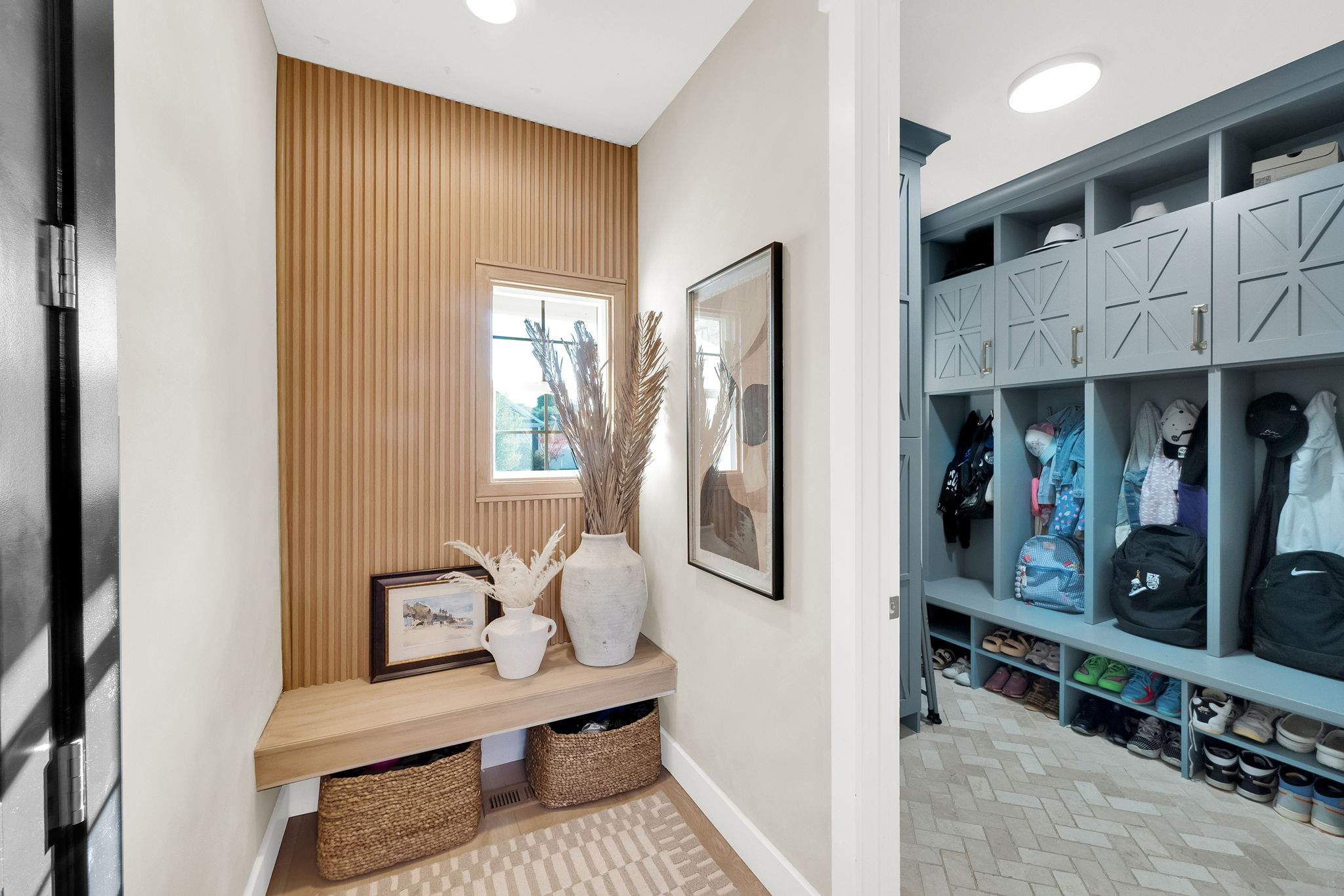 Entryway featuring a built-in wood-finish bench and a slatted accent wall