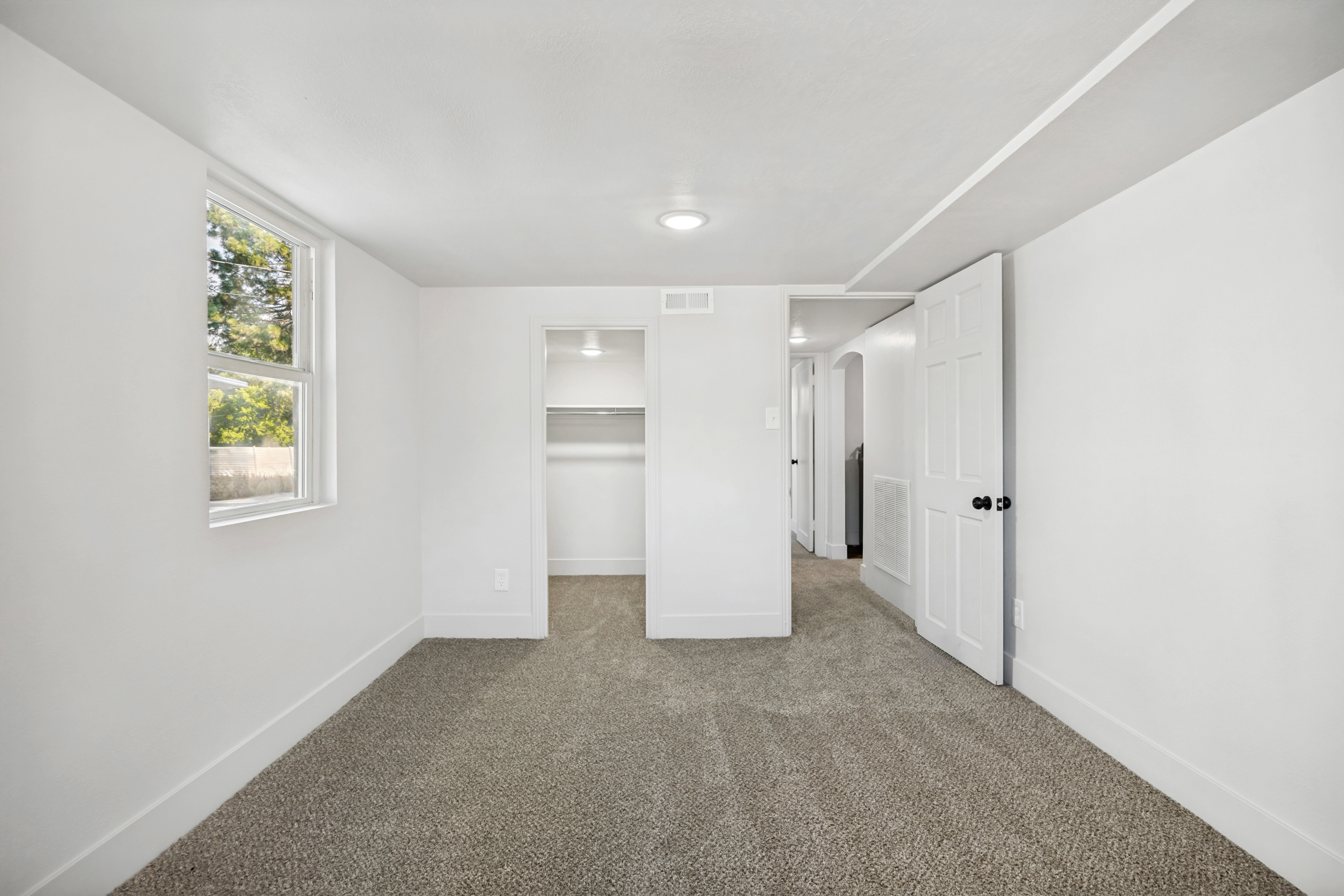 Carpeted room featuring a double-hung window, recessed lighting, and a built-in closet with shelving