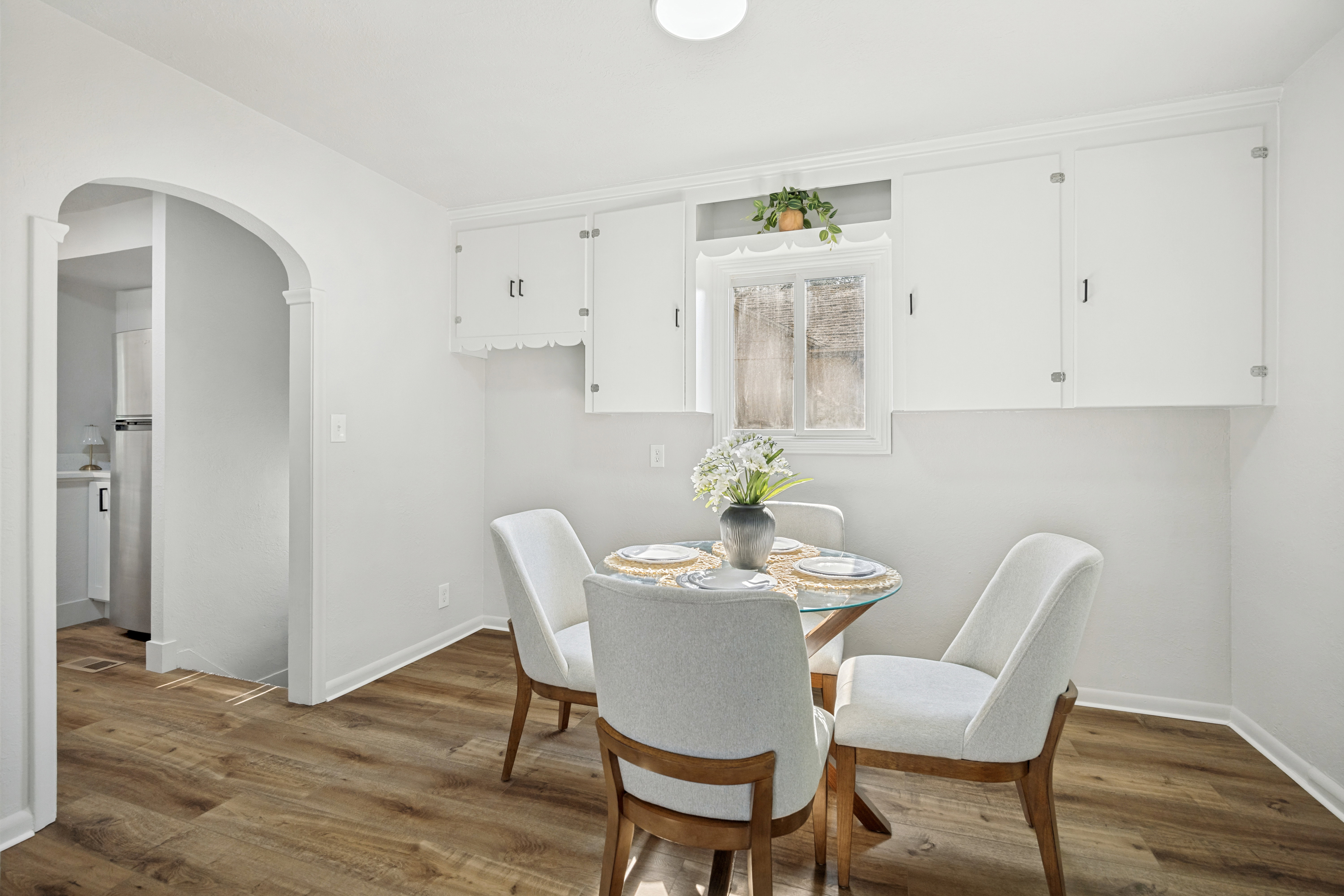 Dining area featuring wood-finish flooring and an arched doorway