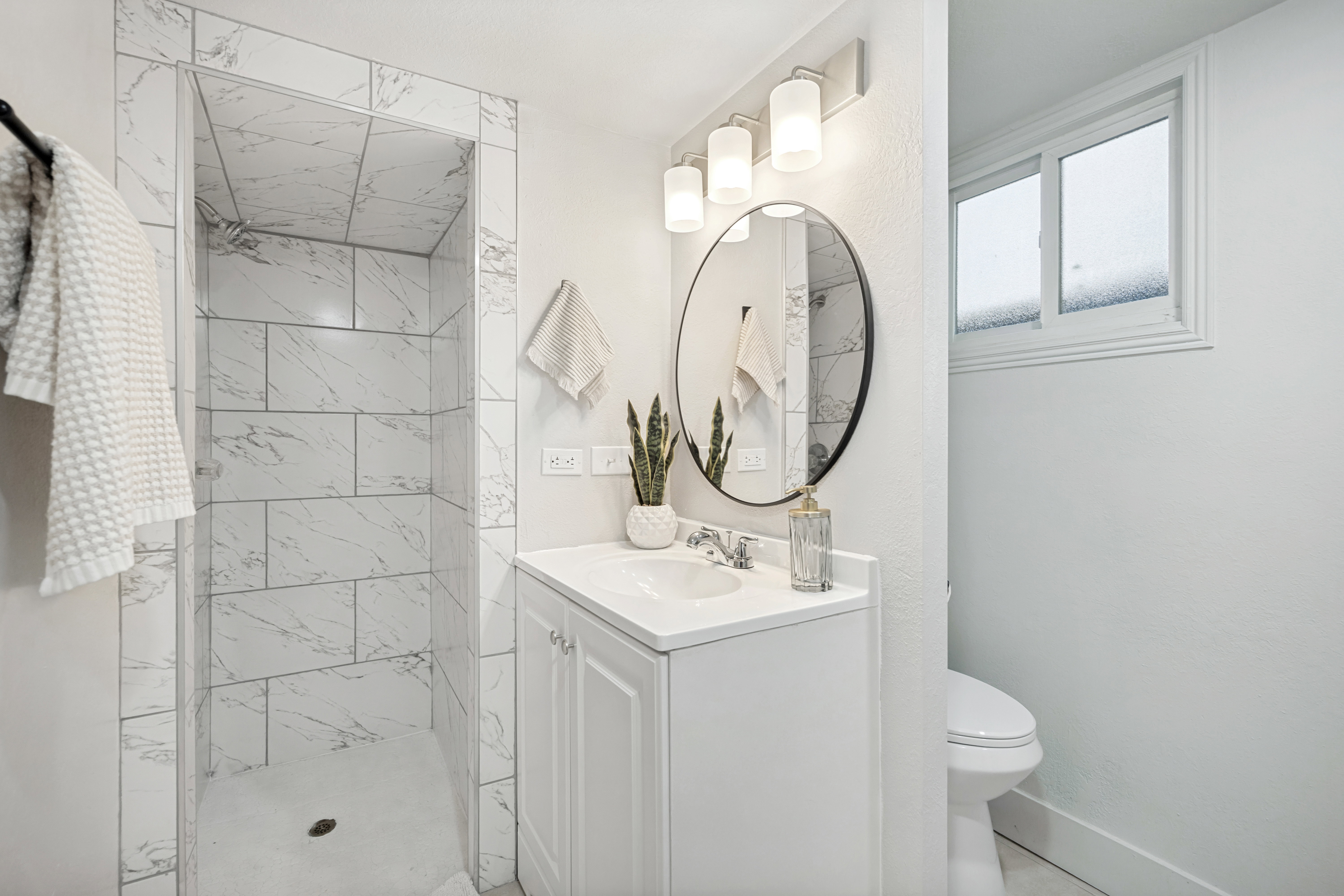 Walk-in shower with large format tile surround and integrated niche