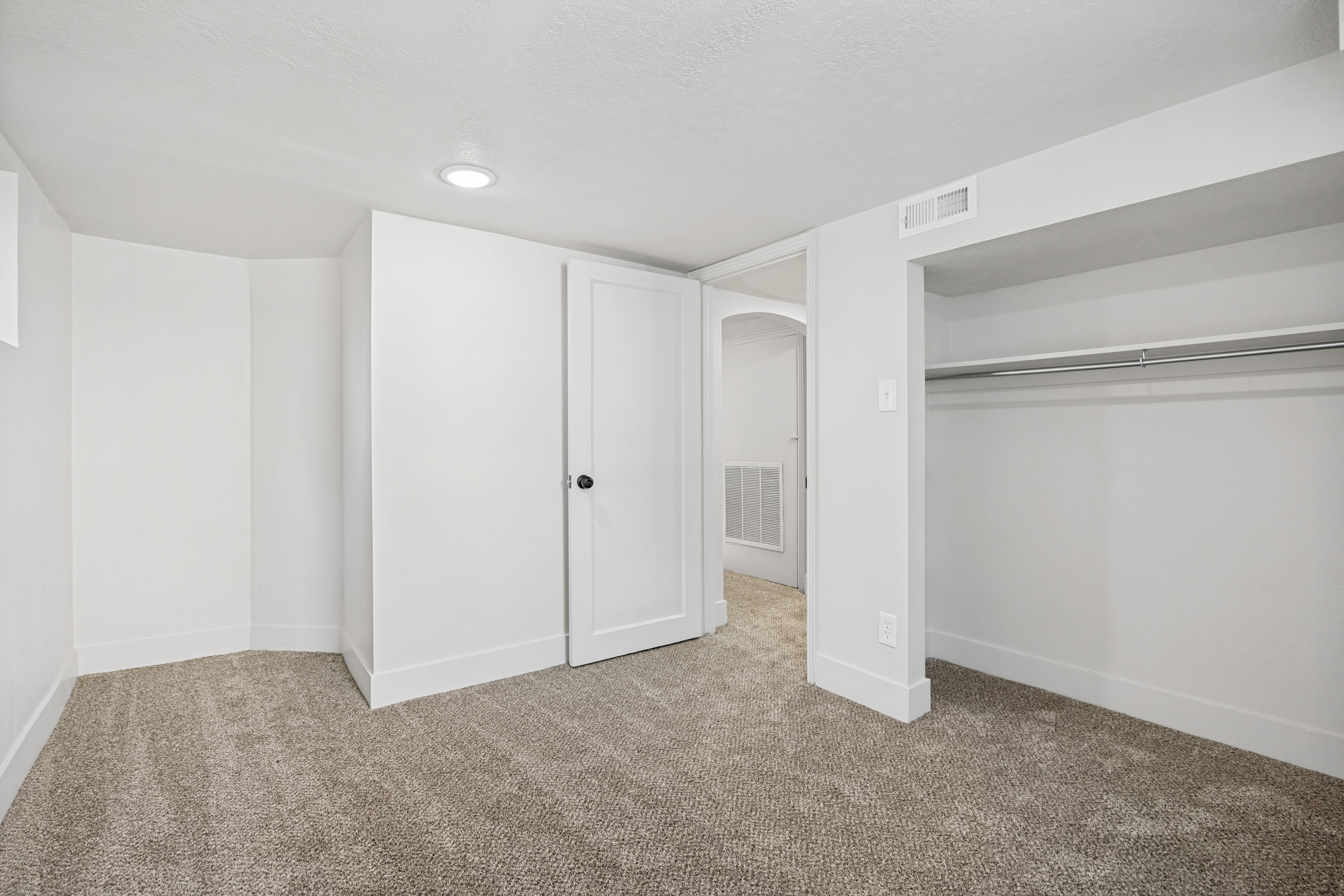 Carpeted room featuring white walls, recessed ceiling lighting, a built-in closet with hanging rod, and white trim throughout