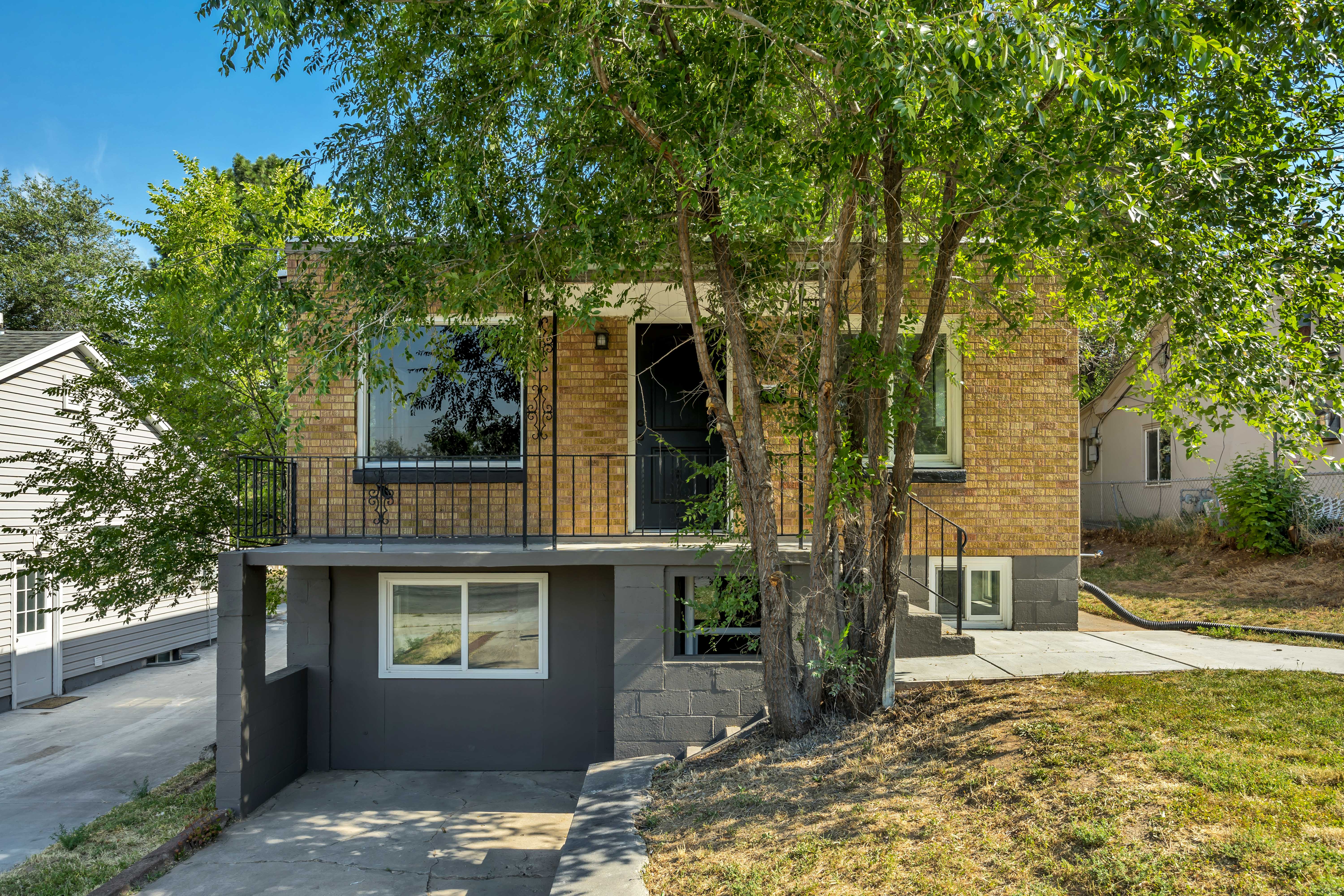 Brick exterior with a second-story balcony featuring black iron railings