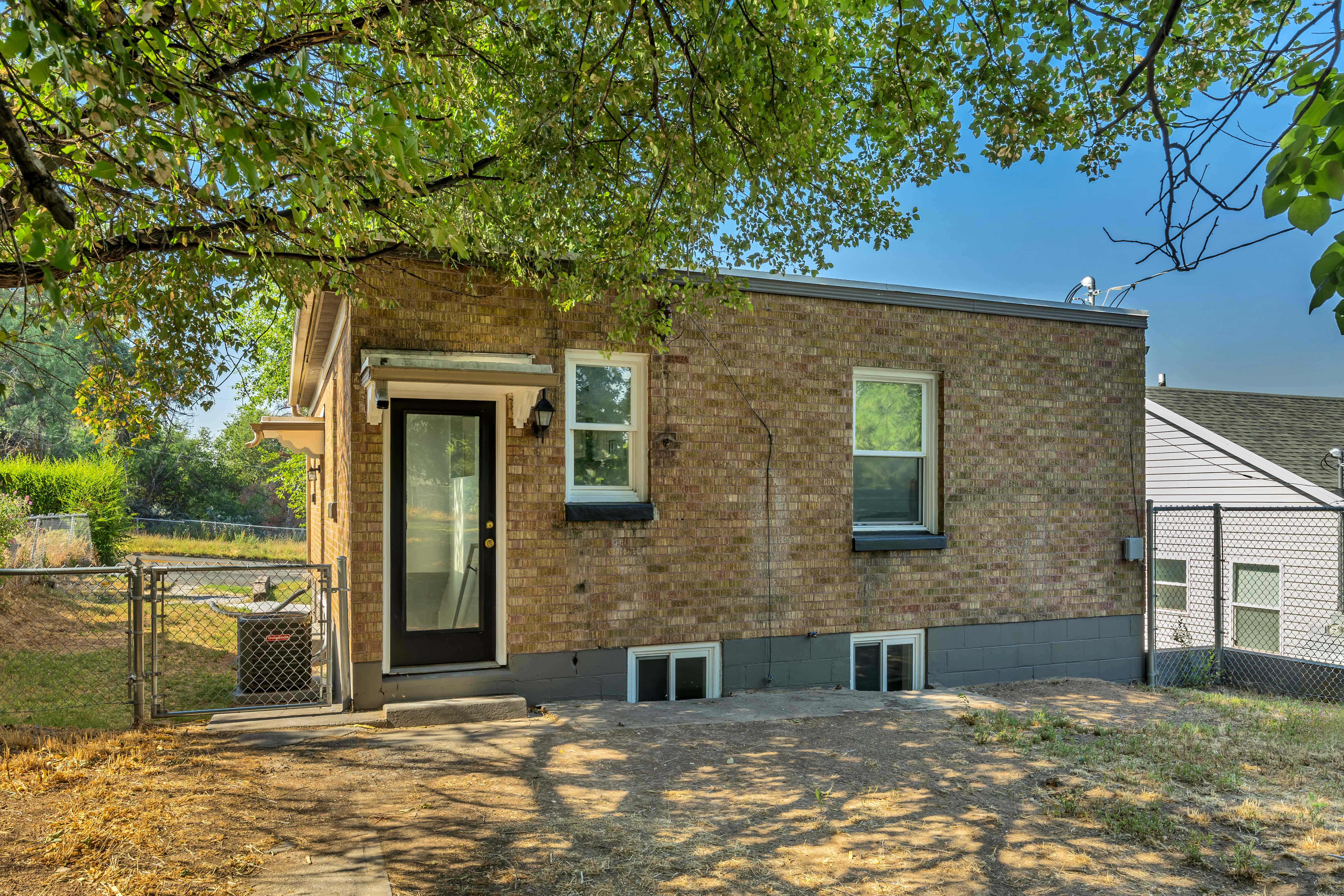 Brick exterior with multiple windows and a black-framed glass door