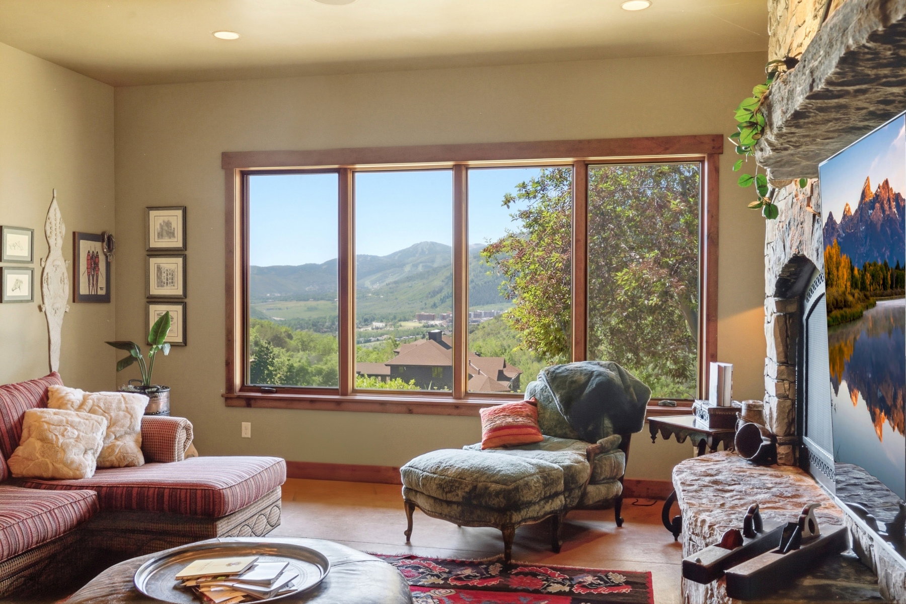 Expansive window wall with natural wood trim offering a mountain and valley backdrop