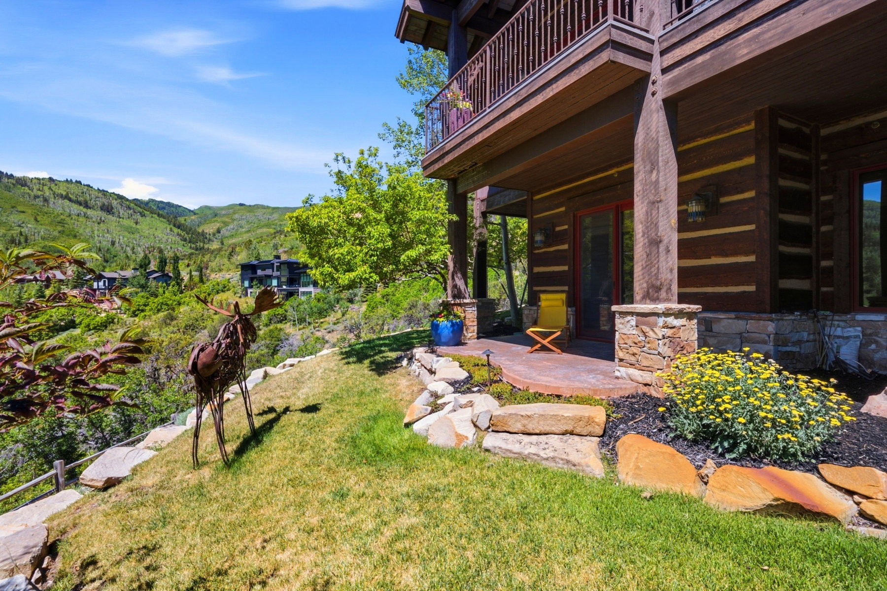 Crafted wood-plank exterior featuring a stone foundation and an upper-level balcony with wood railings
