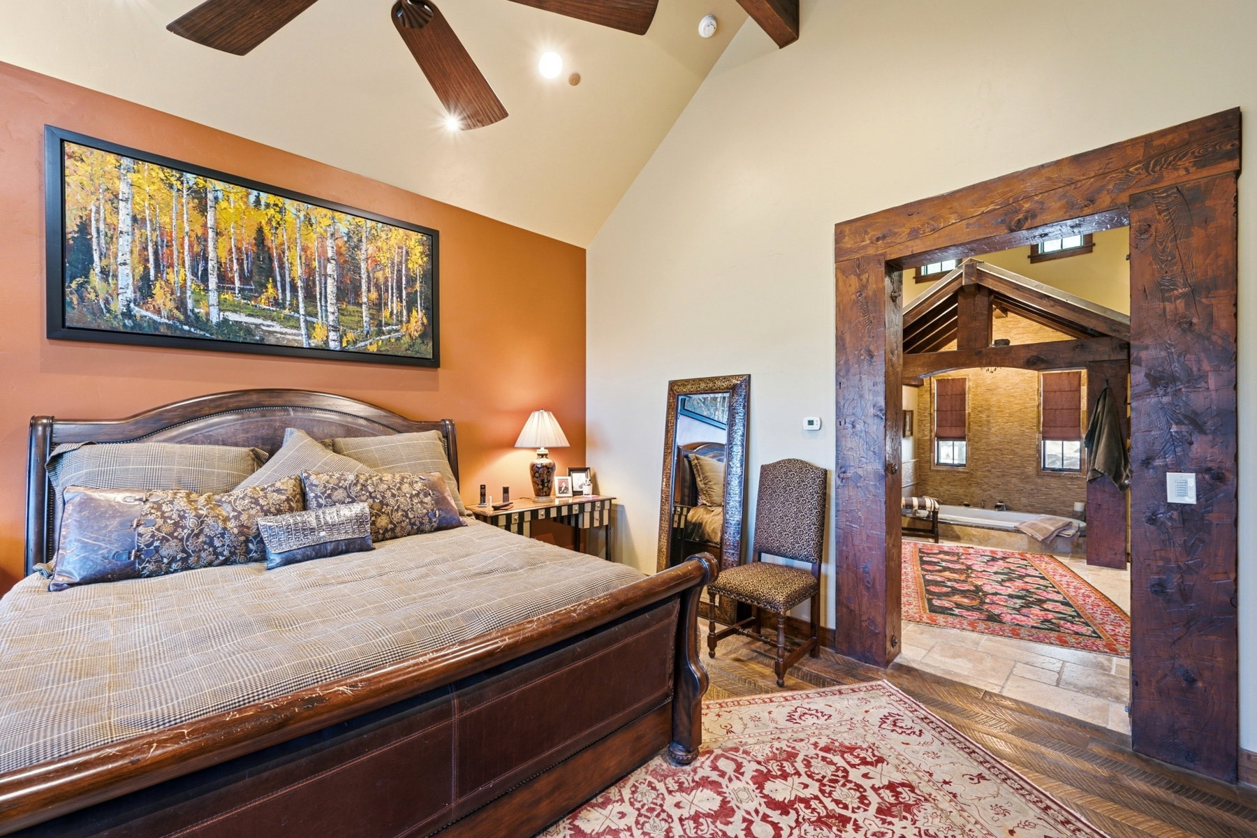 Bedroom with vaulted ceiling and wood-finish ceiling fan