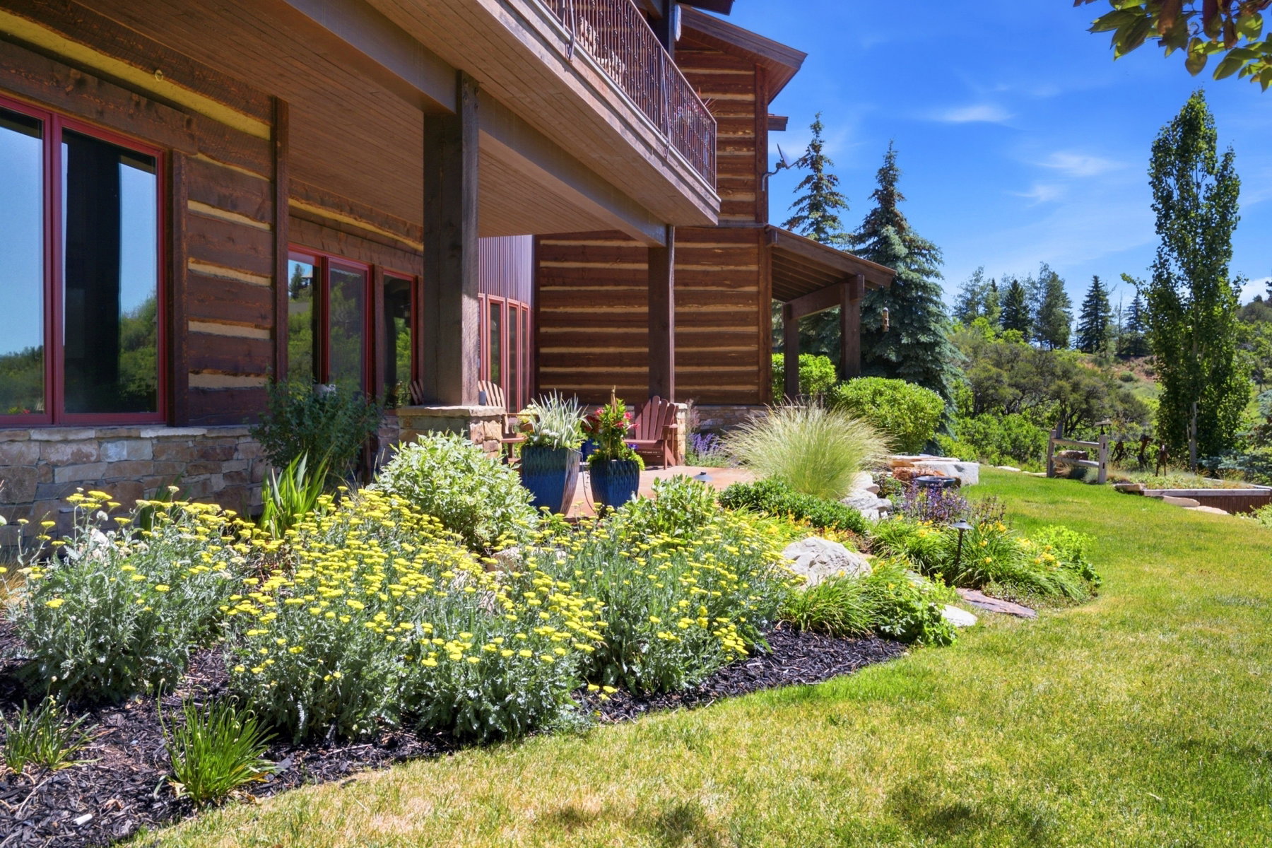 Rustic log cabin exterior with red-framed windows