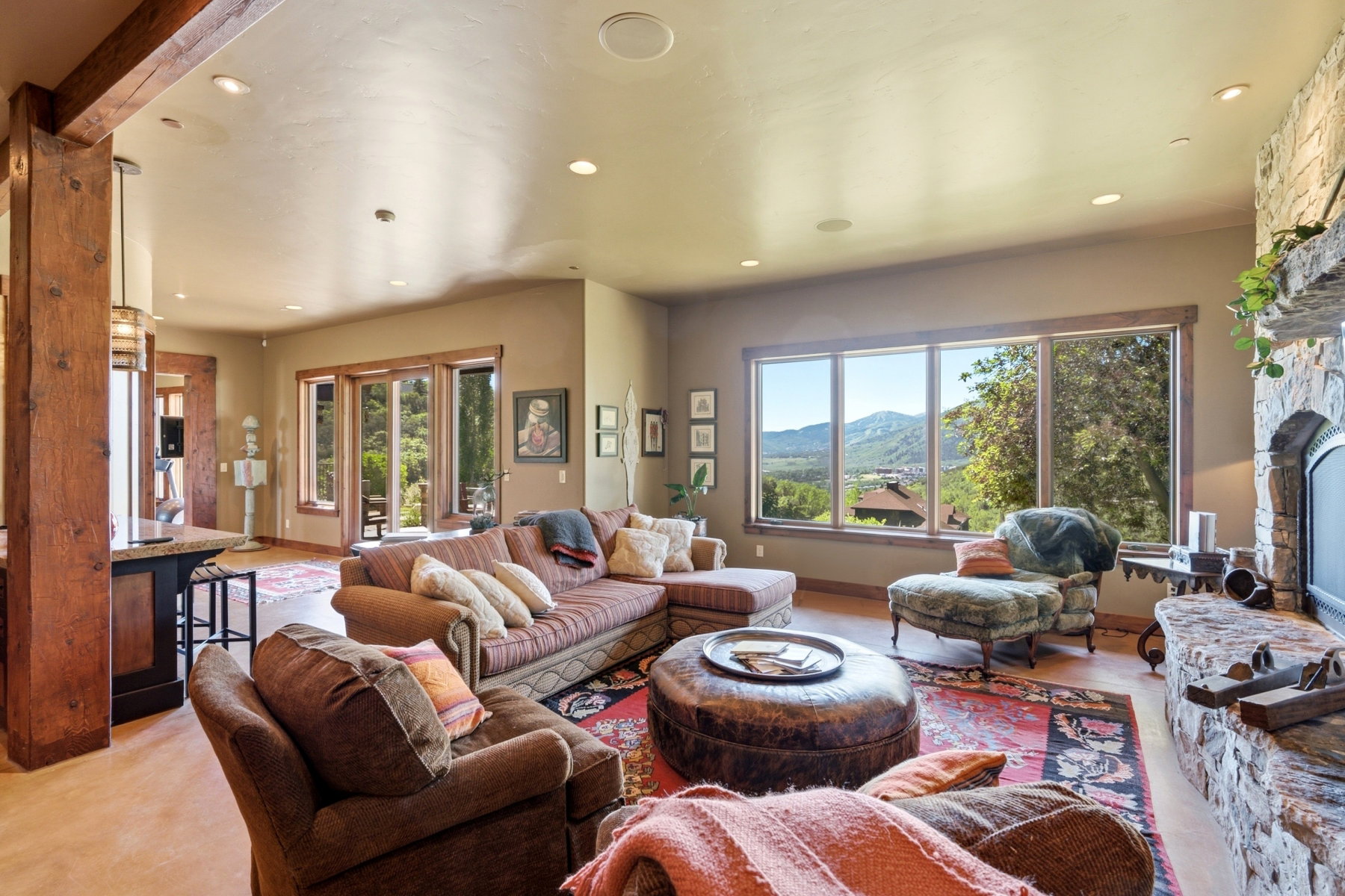 Spacious interior featuring a stone-clad fireplace and large picture windows