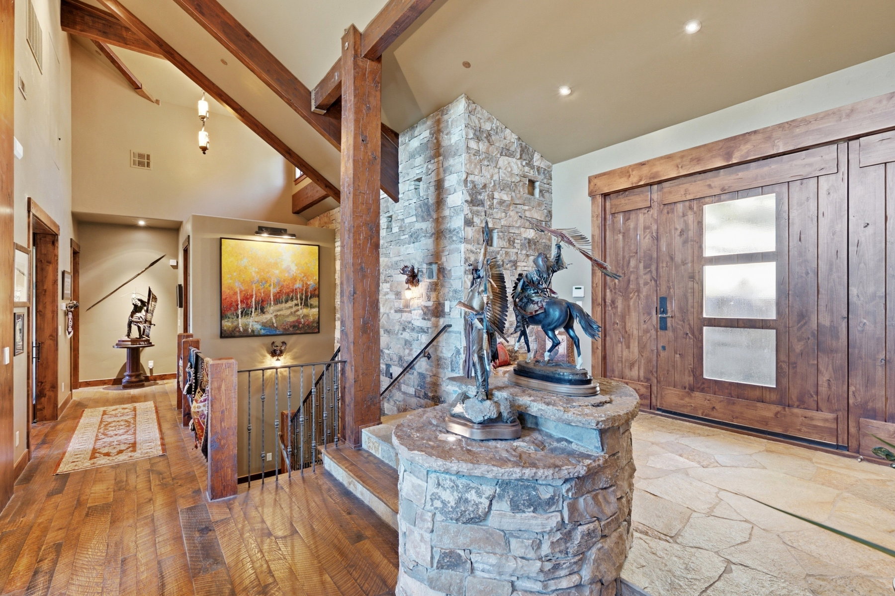 Grand entryway featuring a stone-clad accent wall and flagstone flooring