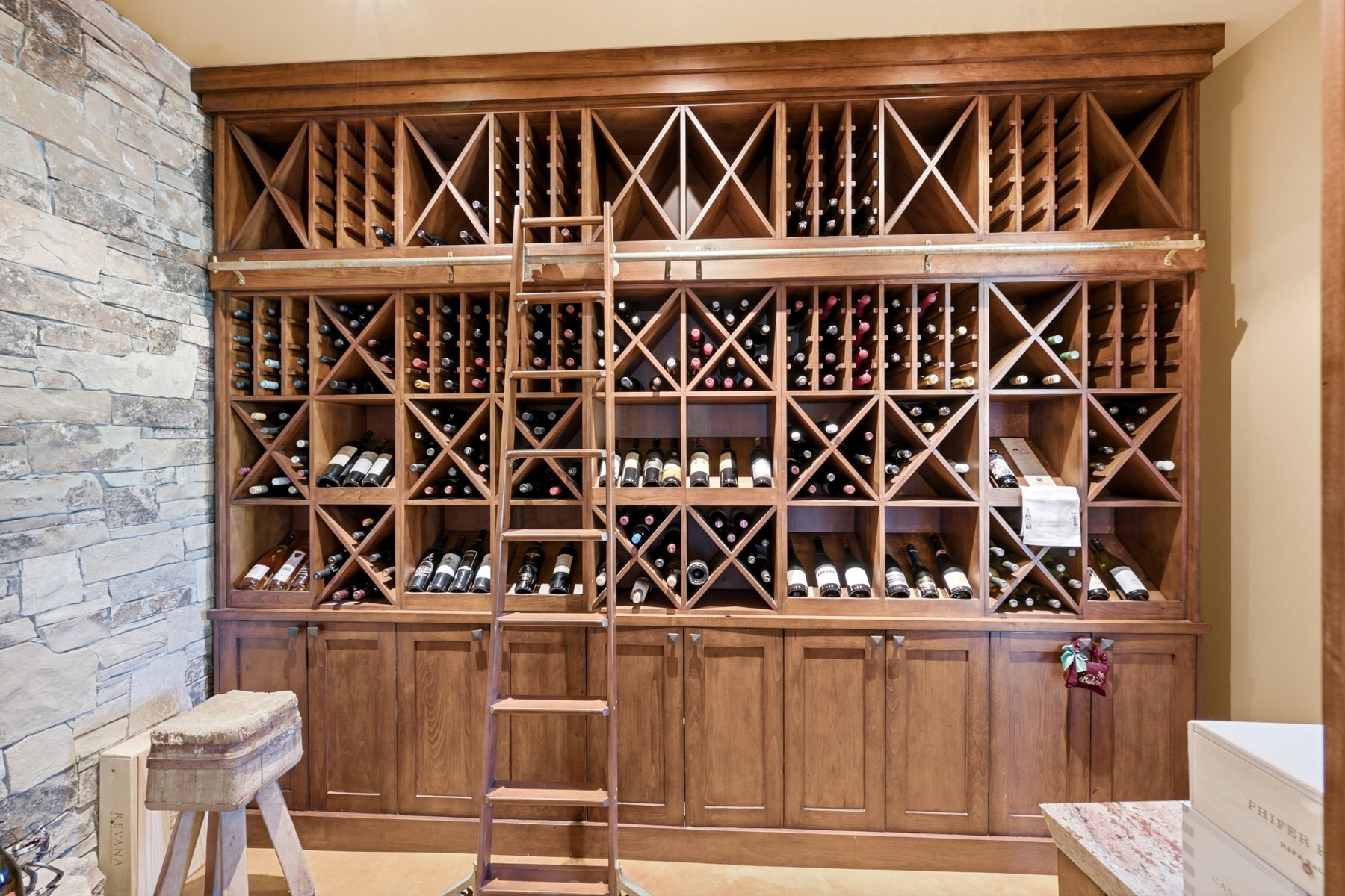 Custom wood-finish wine storage system featuring multiple bottle compartments, full-height design, and integrated base cabinetry
