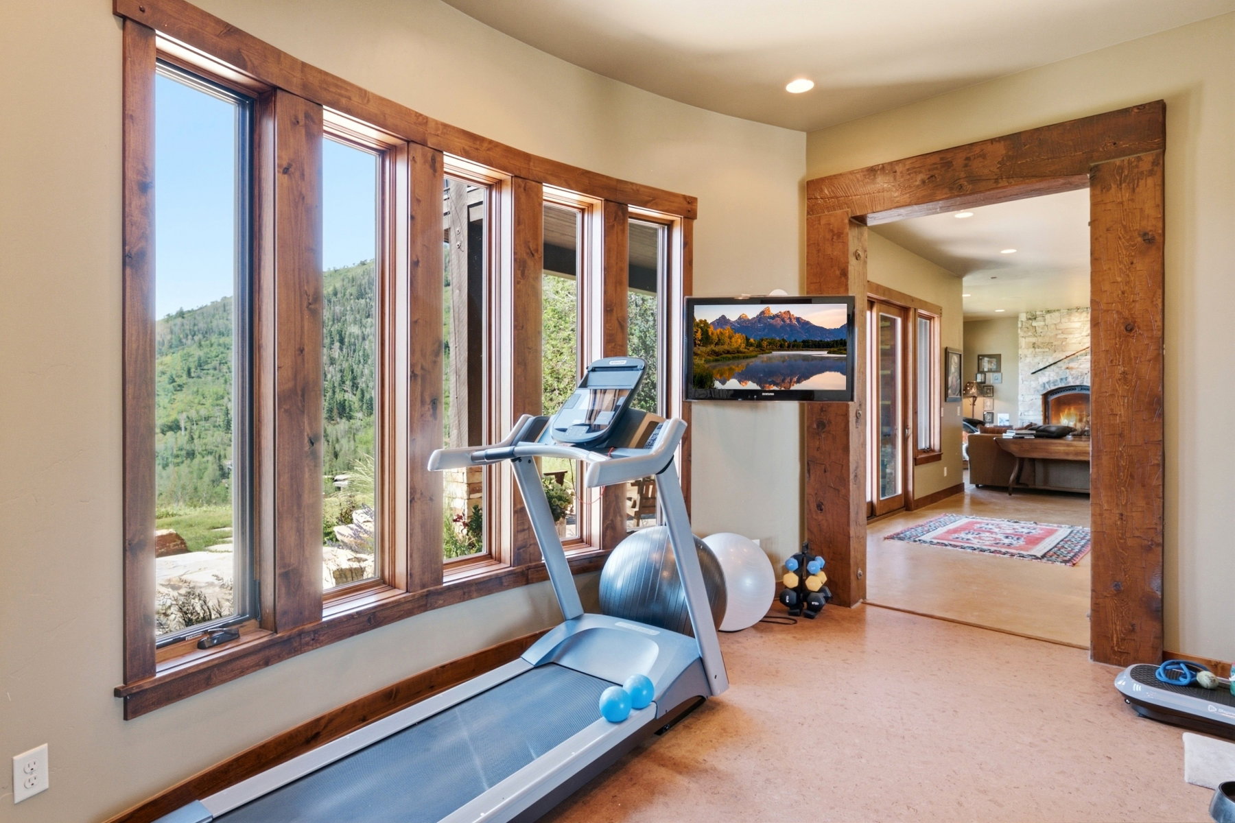 Expansive windows with rustic wood trim provide abundant natural light and scenic mountain views
