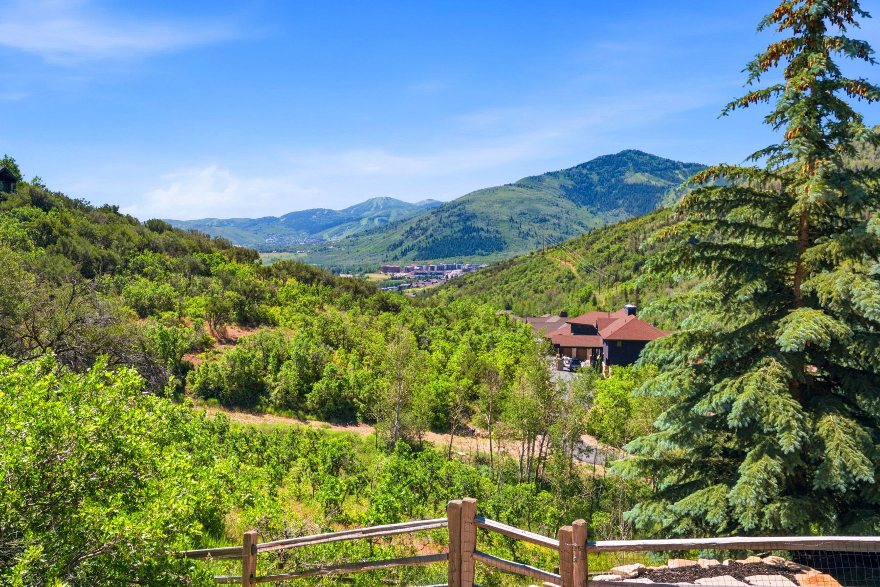 Mountainous landscape with lush green foliage and distant structures