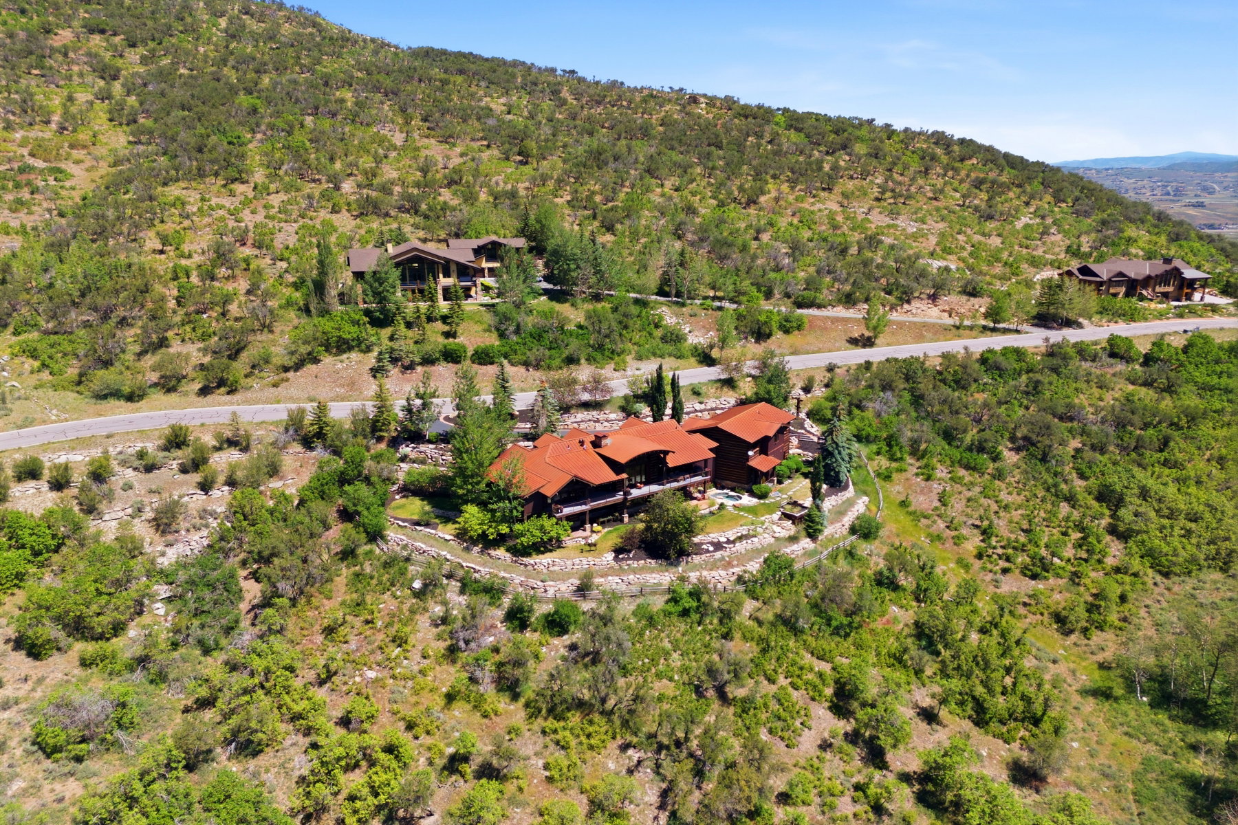 Hillside property featuring a multi-level design with extensive terraced landscaping and mature trees