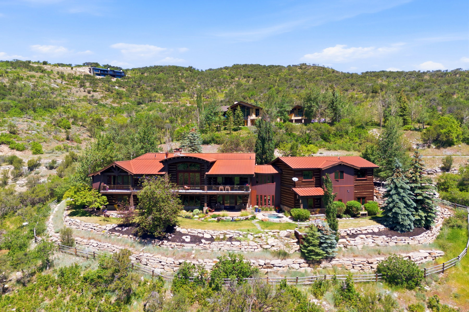 Multi-level property with reddish-brown exterior siding and red-tiled roofing