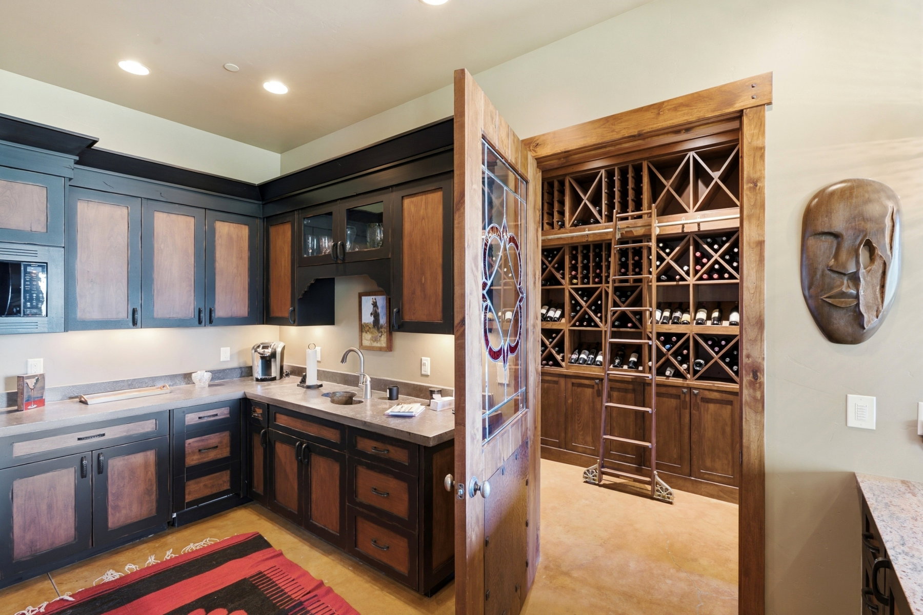 Dedicated wine cellar featuring extensive built-in wooden storage and a rolling ladder