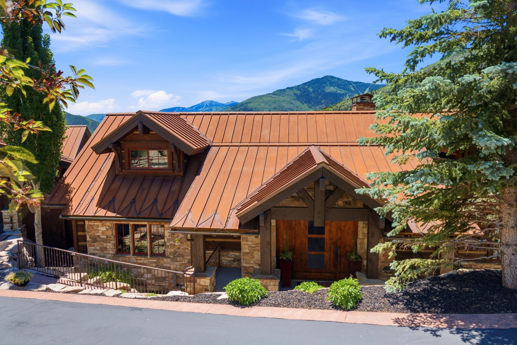 Stone and wood-clad exterior featuring a distinctive metal roof