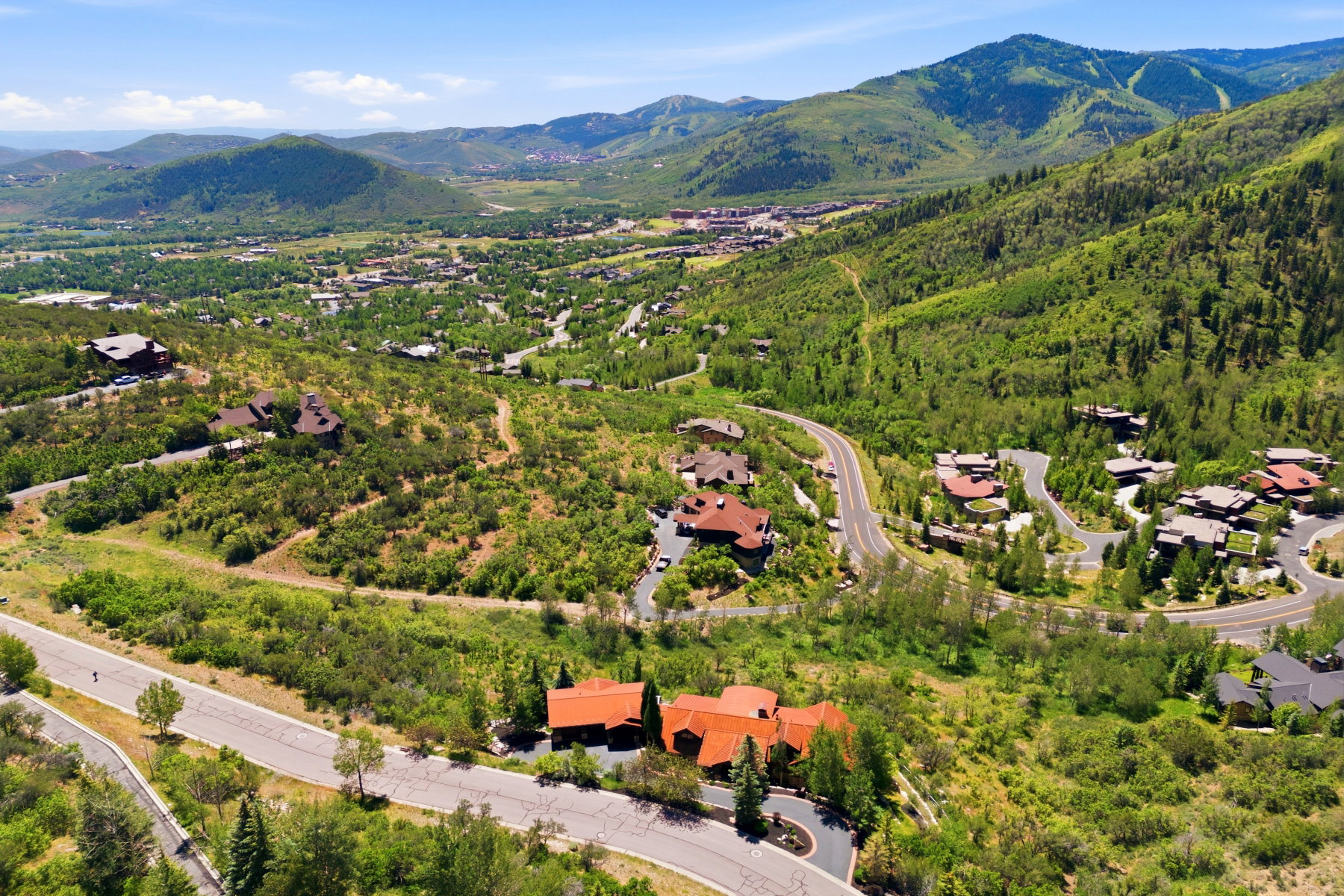 Hillside property featuring a multi-level design with a red tile roof and dark trim