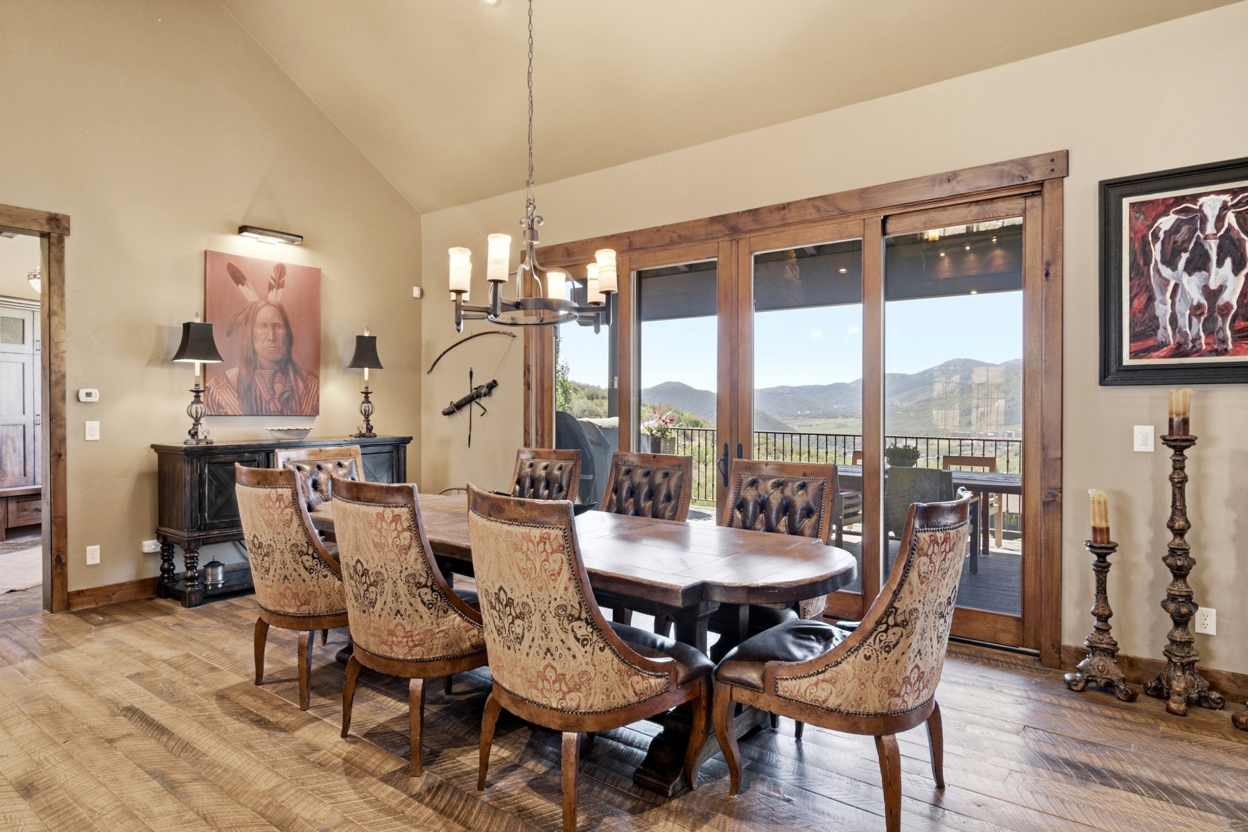 Dining area featuring wood-finish flooring, vaulted ceilings, and rustic wood-framed sliding glass doors