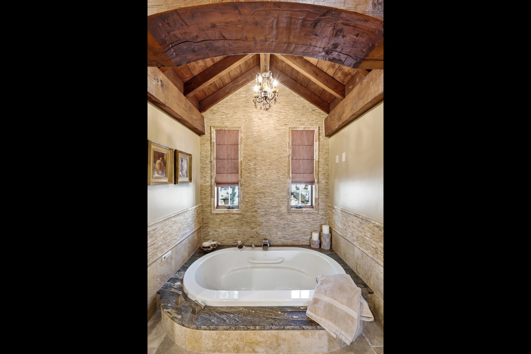 Soaking tub set into a stone surround with a dark stone countertop