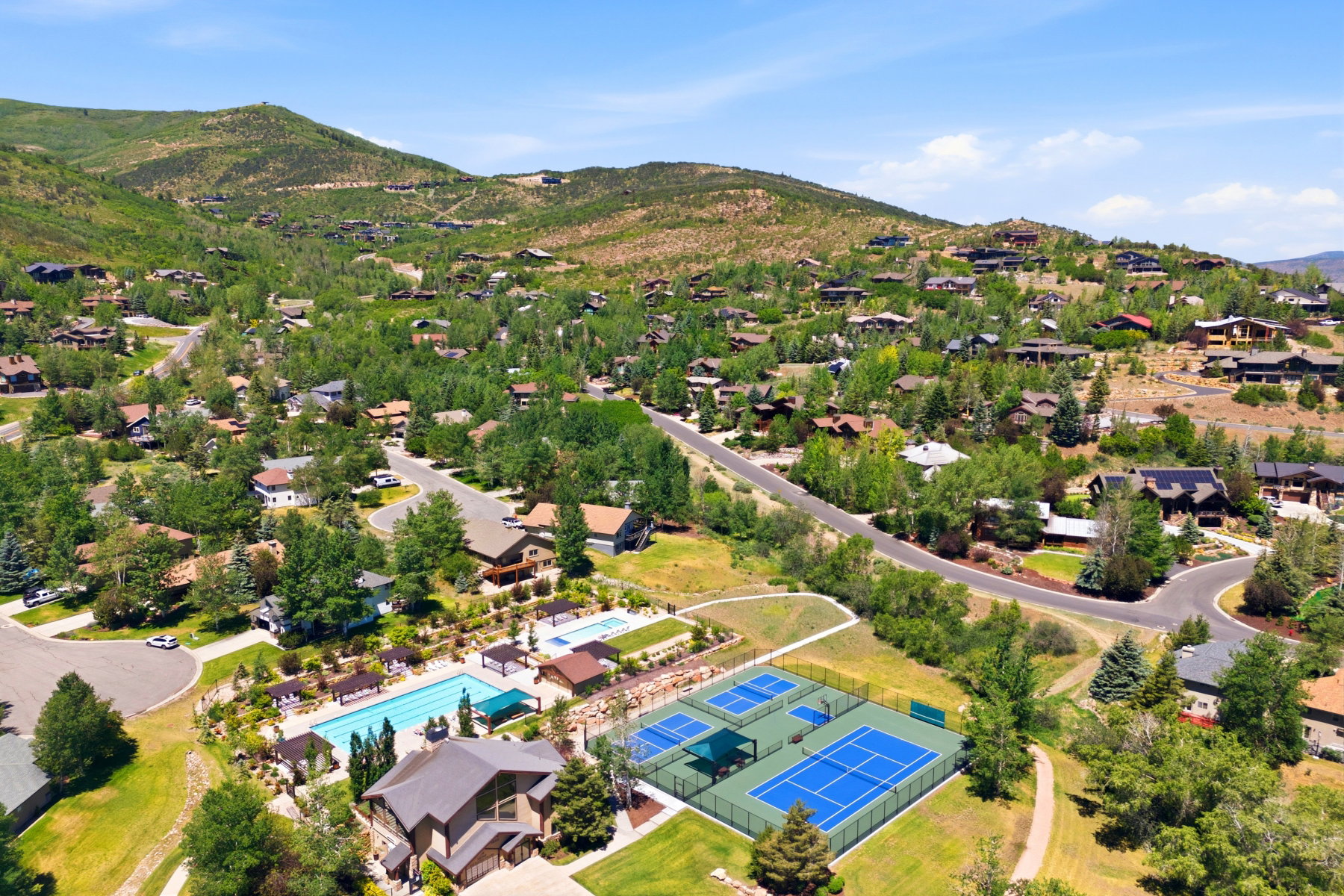 Community amenities featuring multiple swimming pools, sports courts, and a clubhouse building