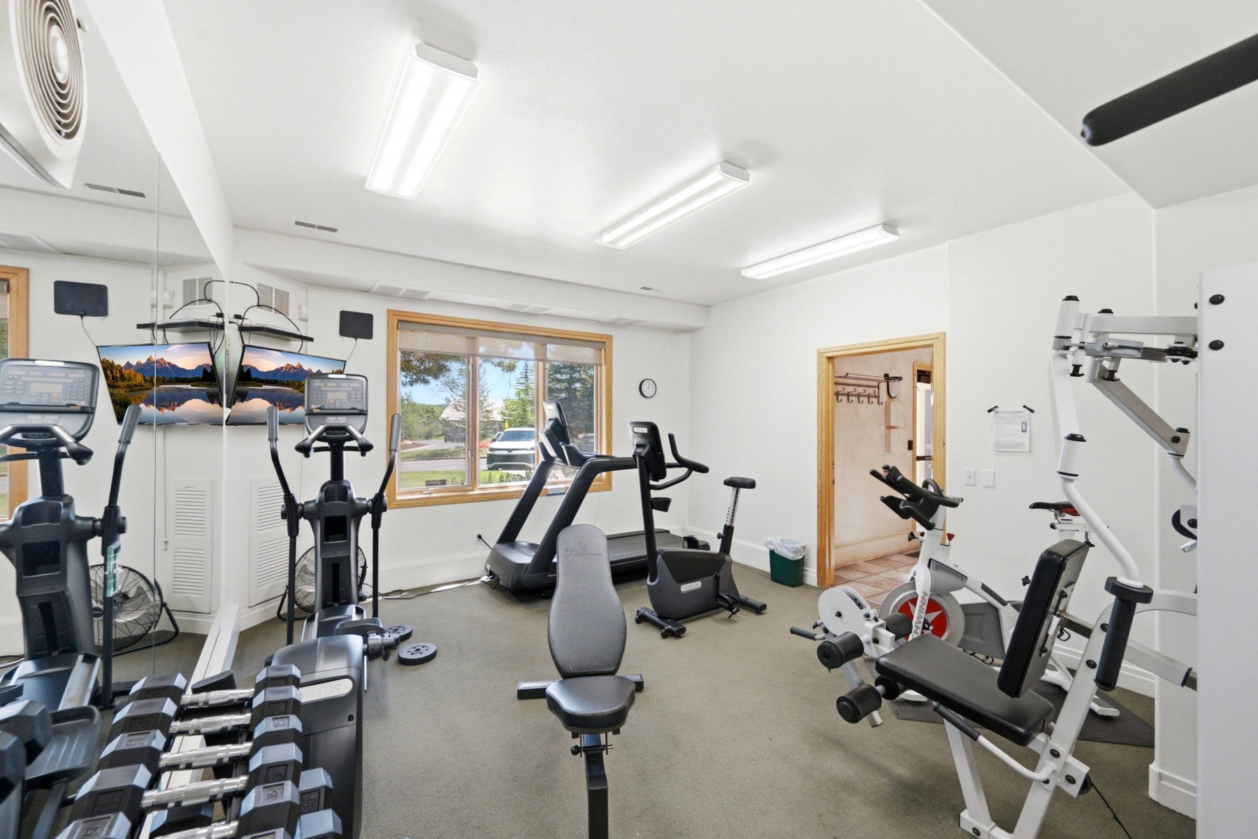 Dedicated fitness space featuring neutral walls, recessed lighting, and a large window