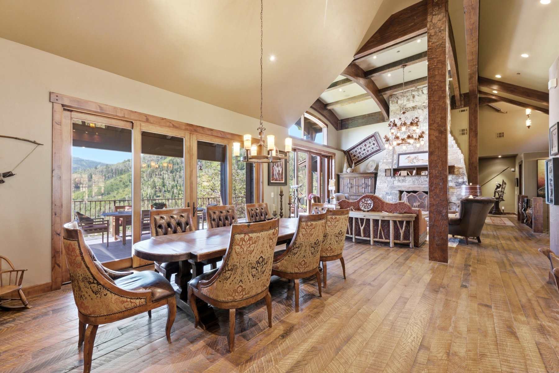 Expansive interior featuring wood-finish flooring, exposed wood beams, and a stone fireplace
