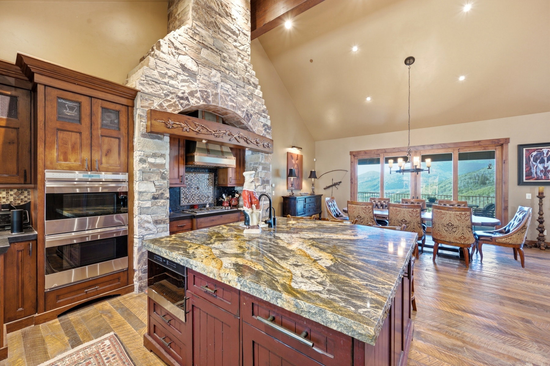 Spacious kitchen featuring a large island with a stone countertop, built-in wine cooler, and sink