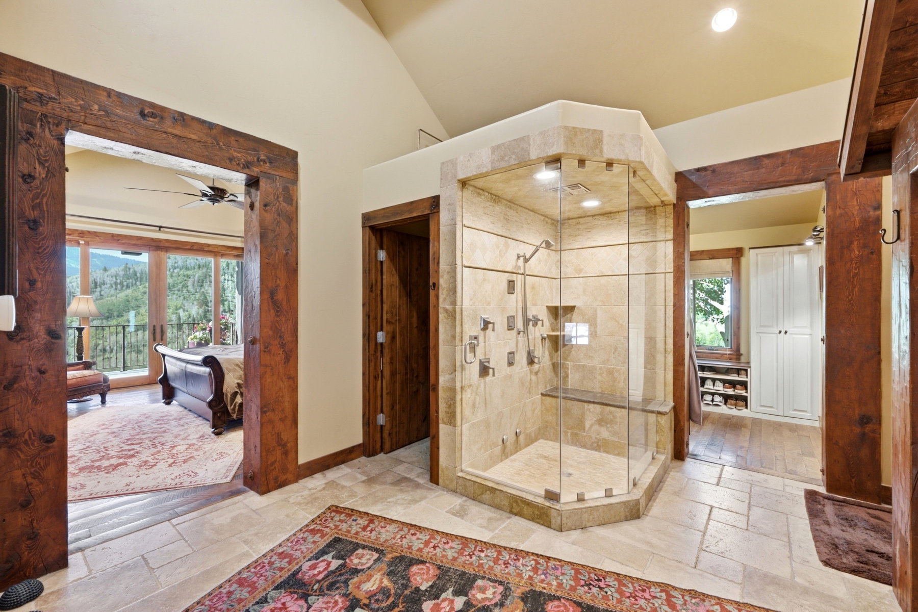 Expansive walk-in shower with multiple showerheads, integrated seating, and full-height tile enclosure