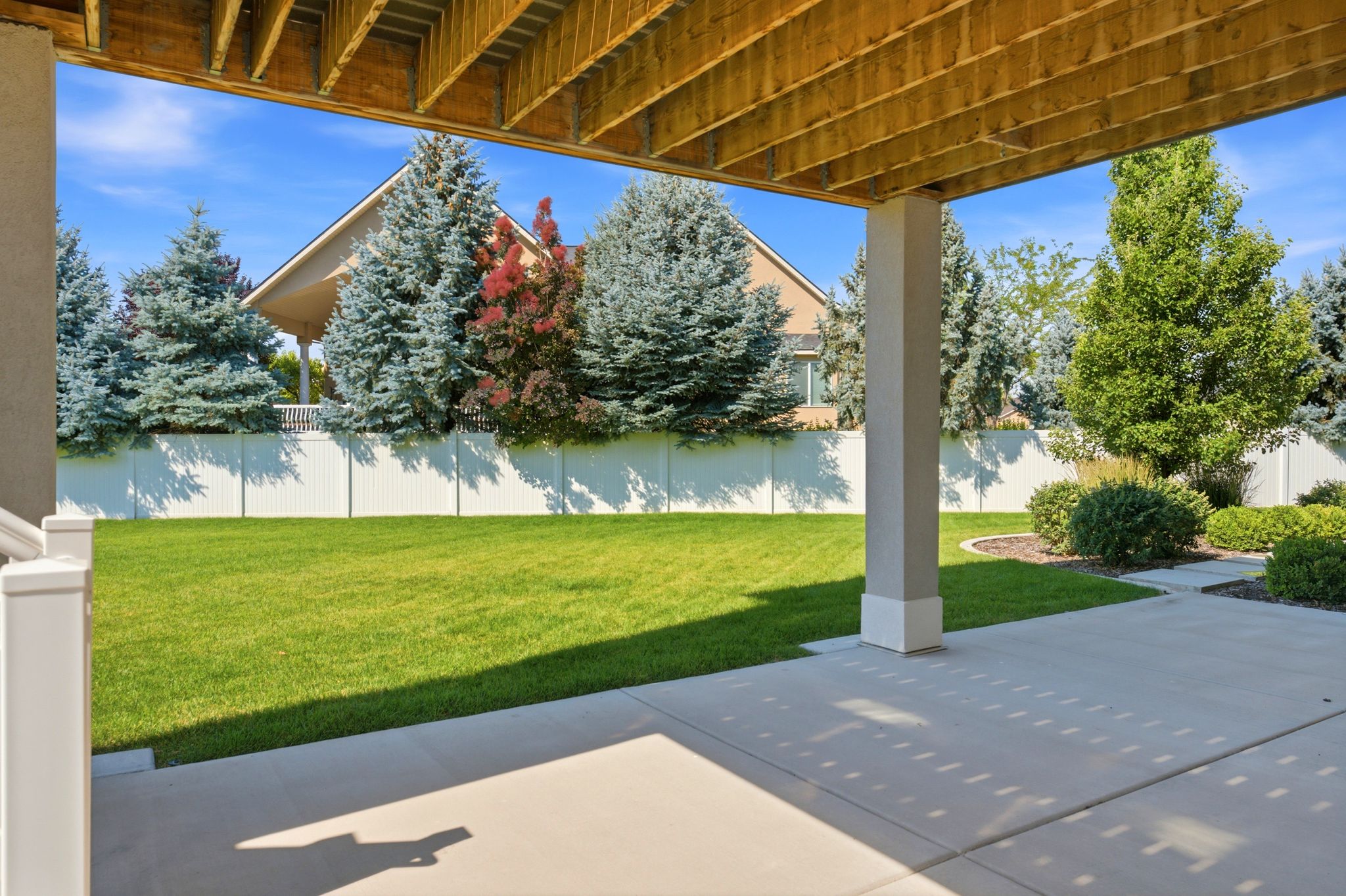Covered patio with exposed wood joists and a concrete surface
