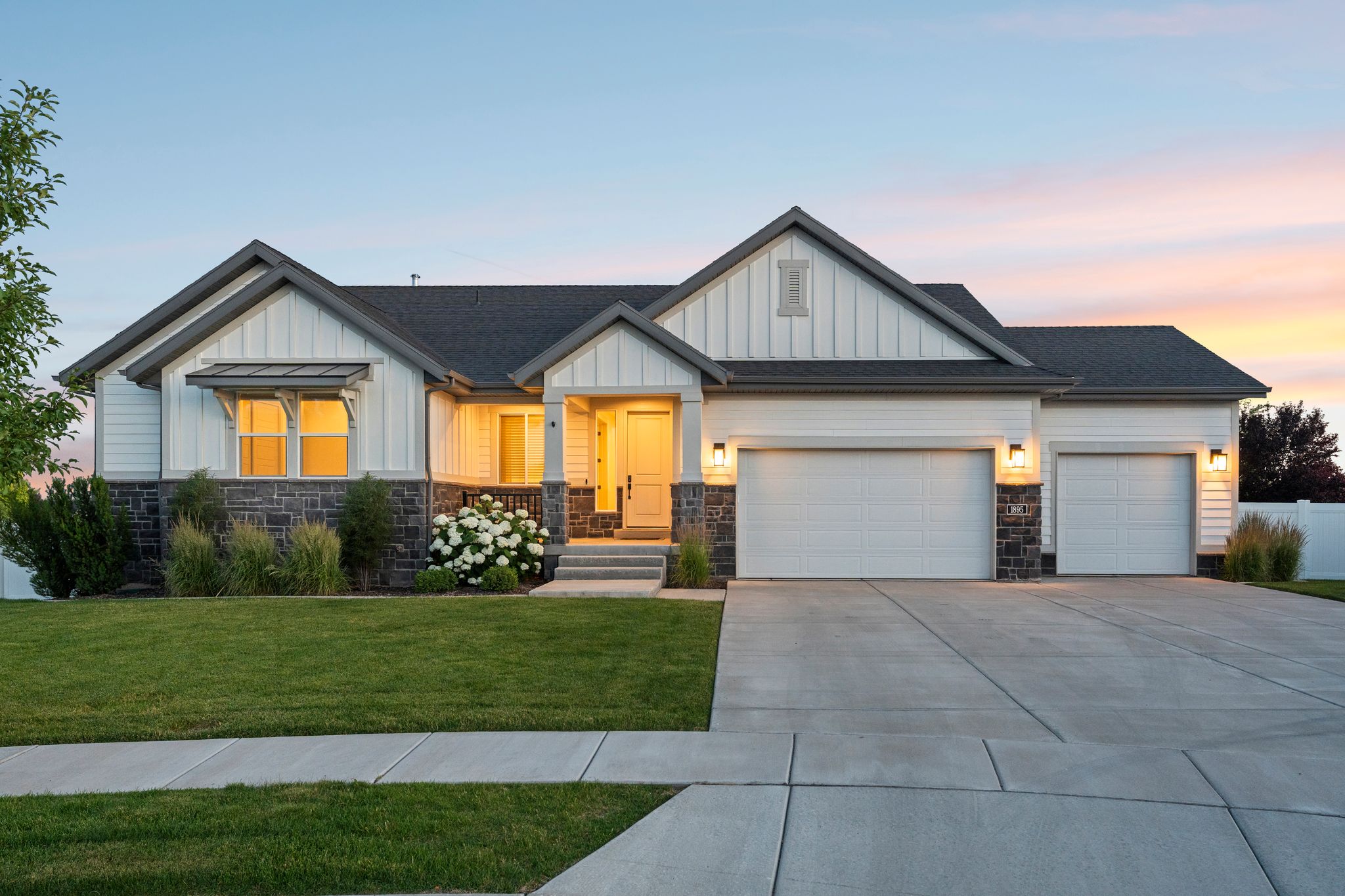 White siding exterior with dark gray accents and stone detailing