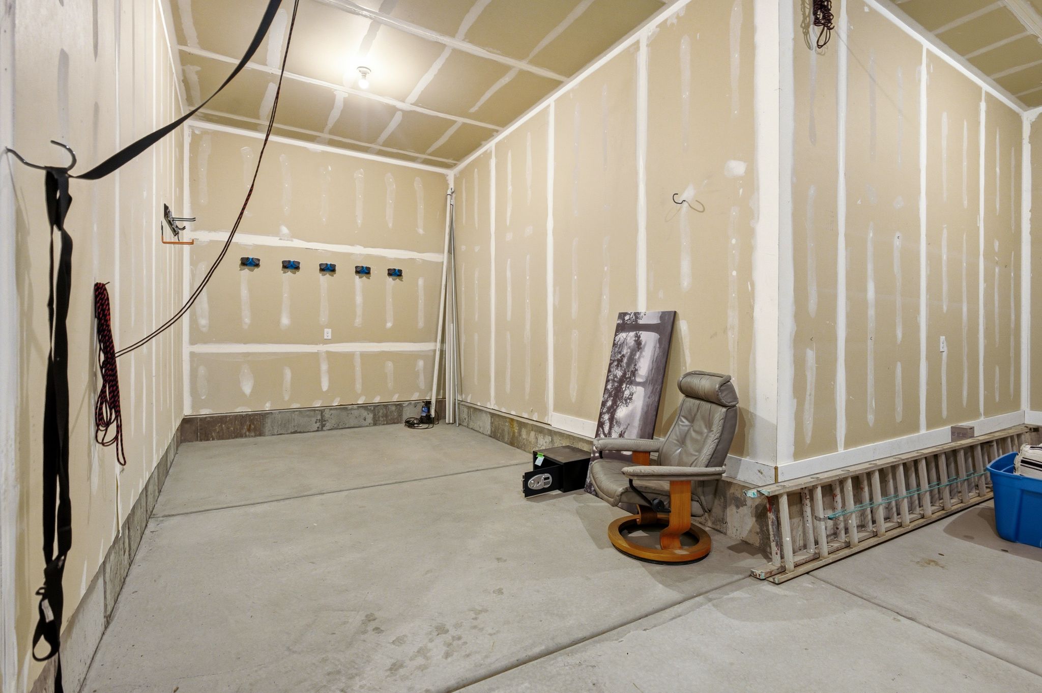 Unfinished interior space featuring a concrete floor, exposed drywall, and visible electrical outlets
