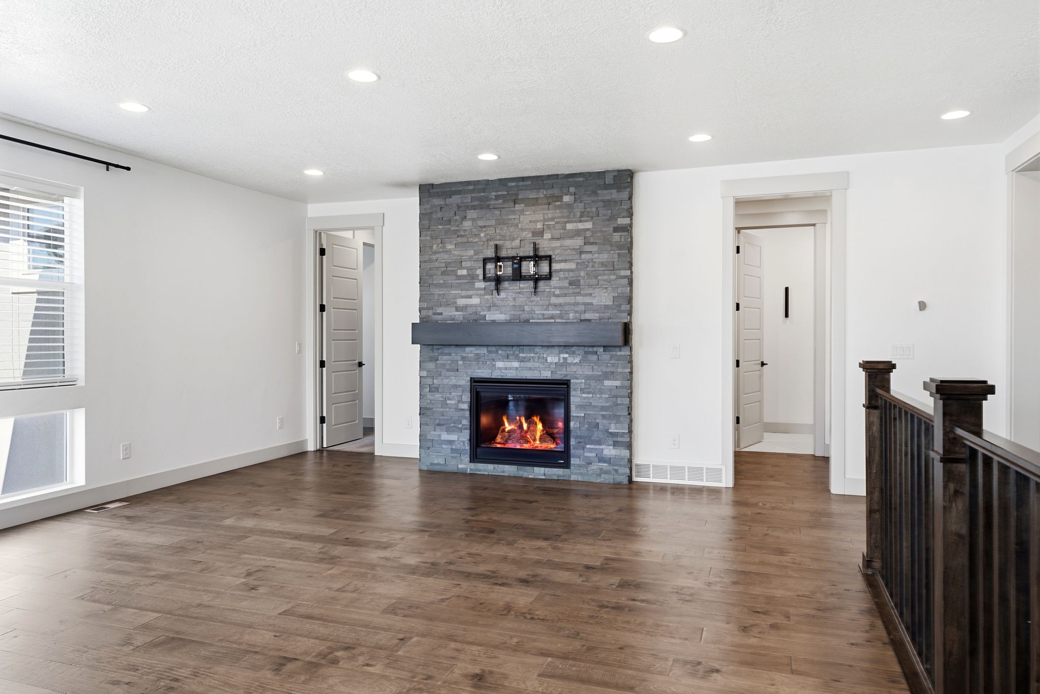 Living area featuring a floor-to-ceiling stone fireplace with a dark wood-finish mantel and a built-in electric insert