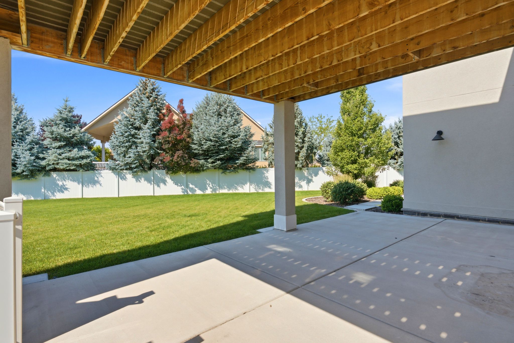 Covered patio with concrete slab flooring and an exposed wood ceiling structure