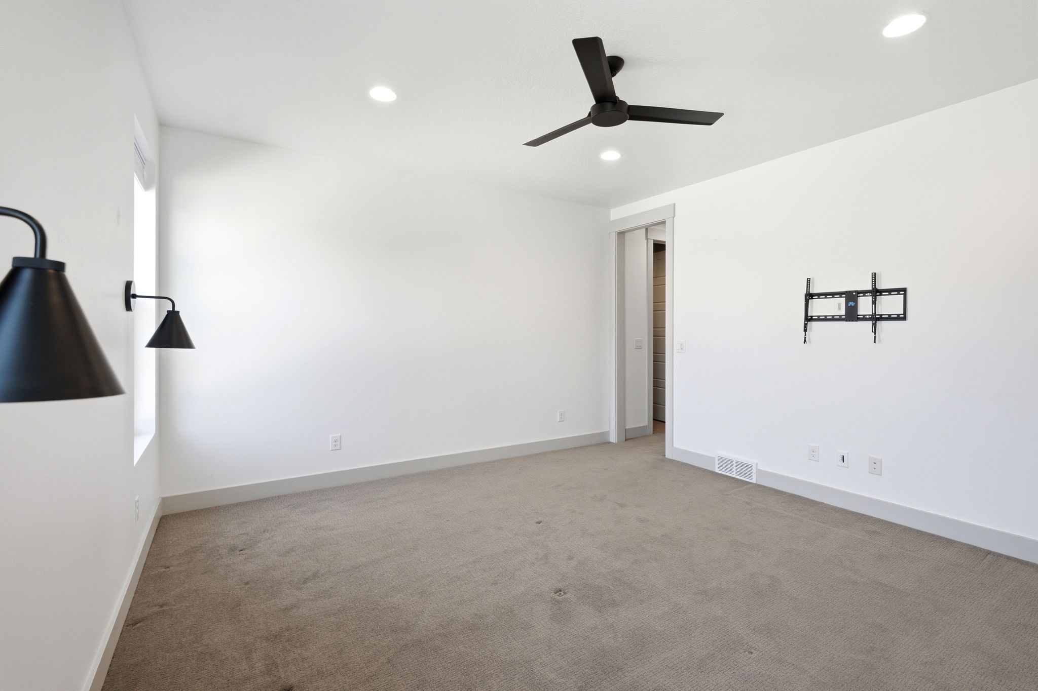 Room featuring light-toned carpeting, white walls, and recessed lighting