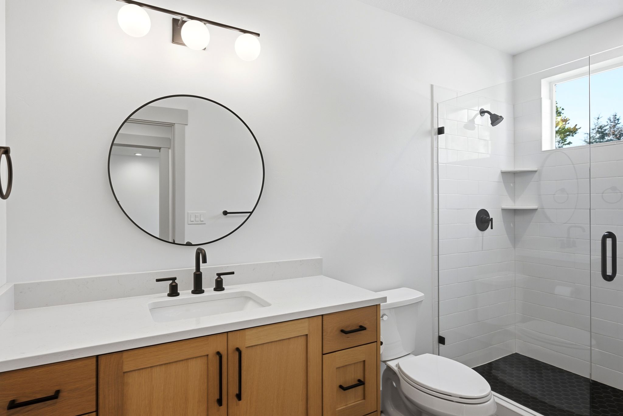 Contemporary bathroom featuring a light wood vanity with a white countertop and rectangular sink