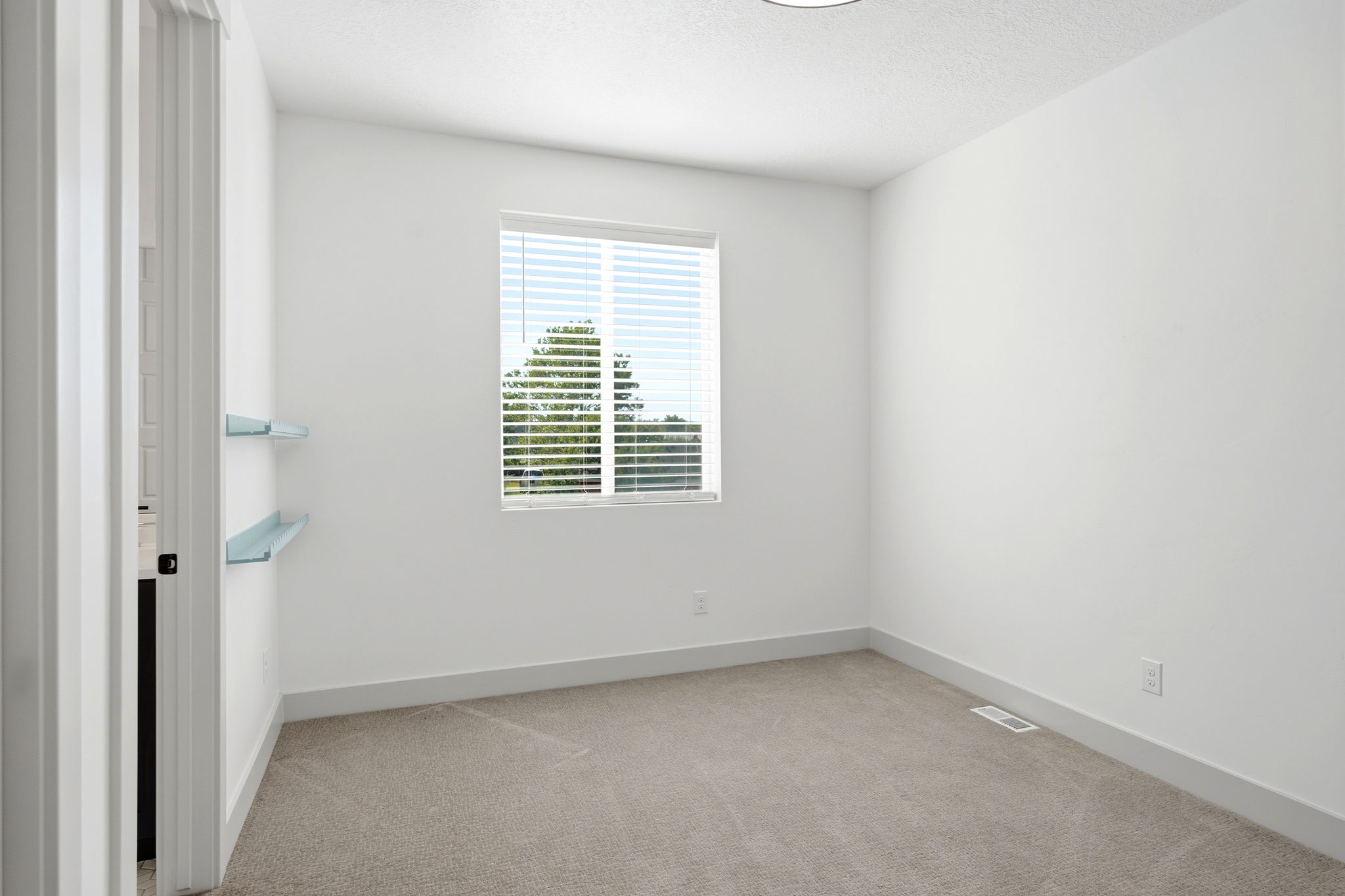 Bright room with a large window and custom built-in shelving