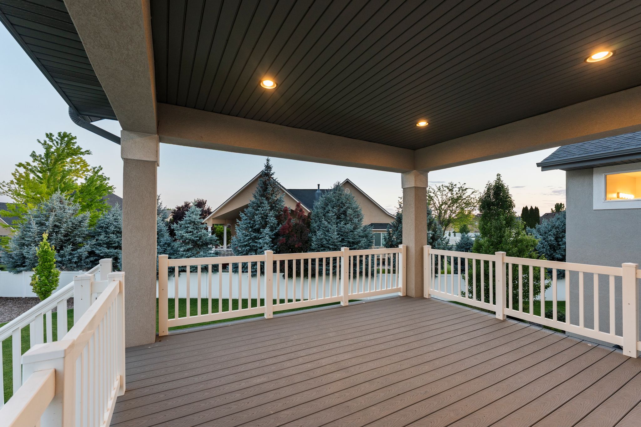 Covered outdoor deck with composite decking and white railings