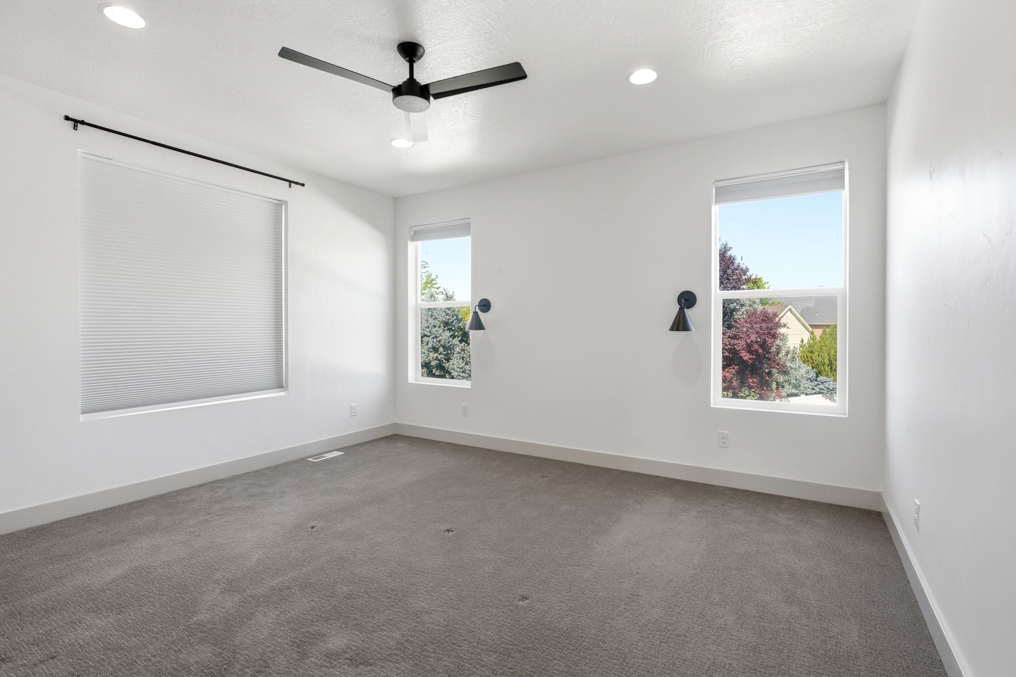 Spacious room featuring neutral carpeting and white walls