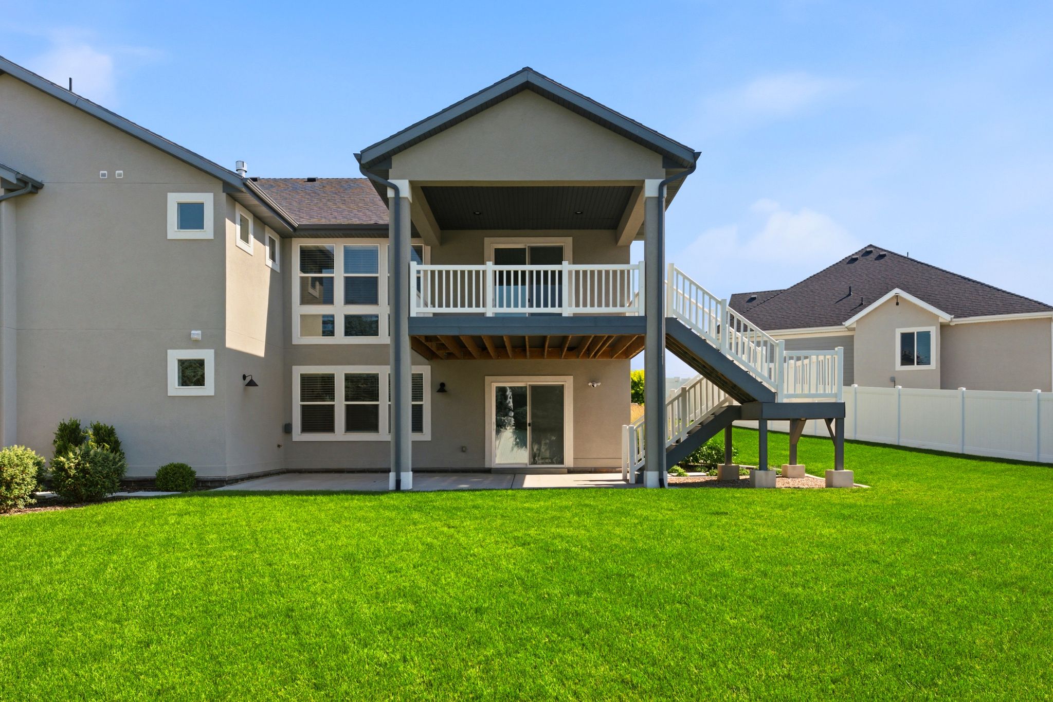 Expansive green lawn with a two-story stucco exterior