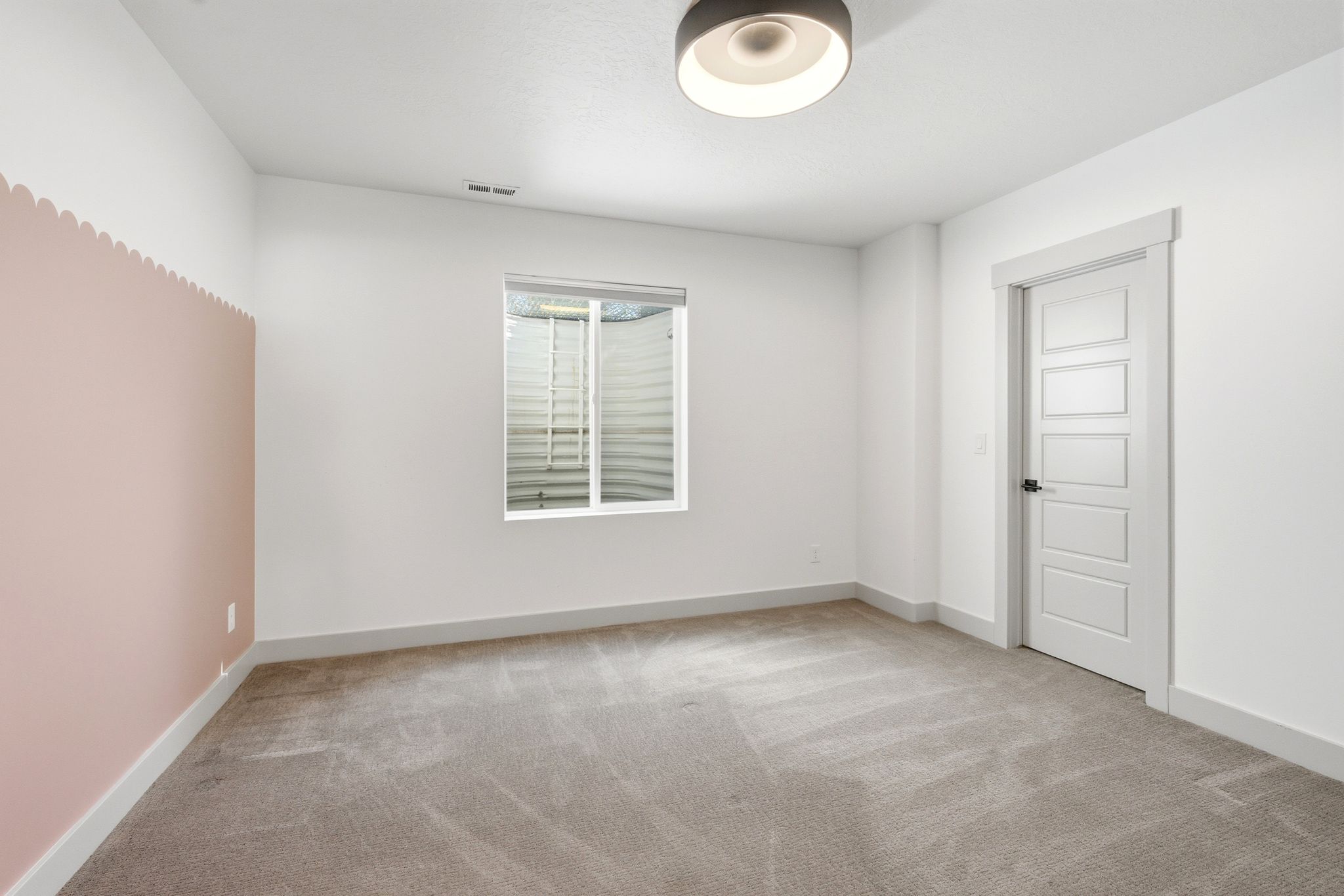 Neutral carpeted flooring with white baseboards