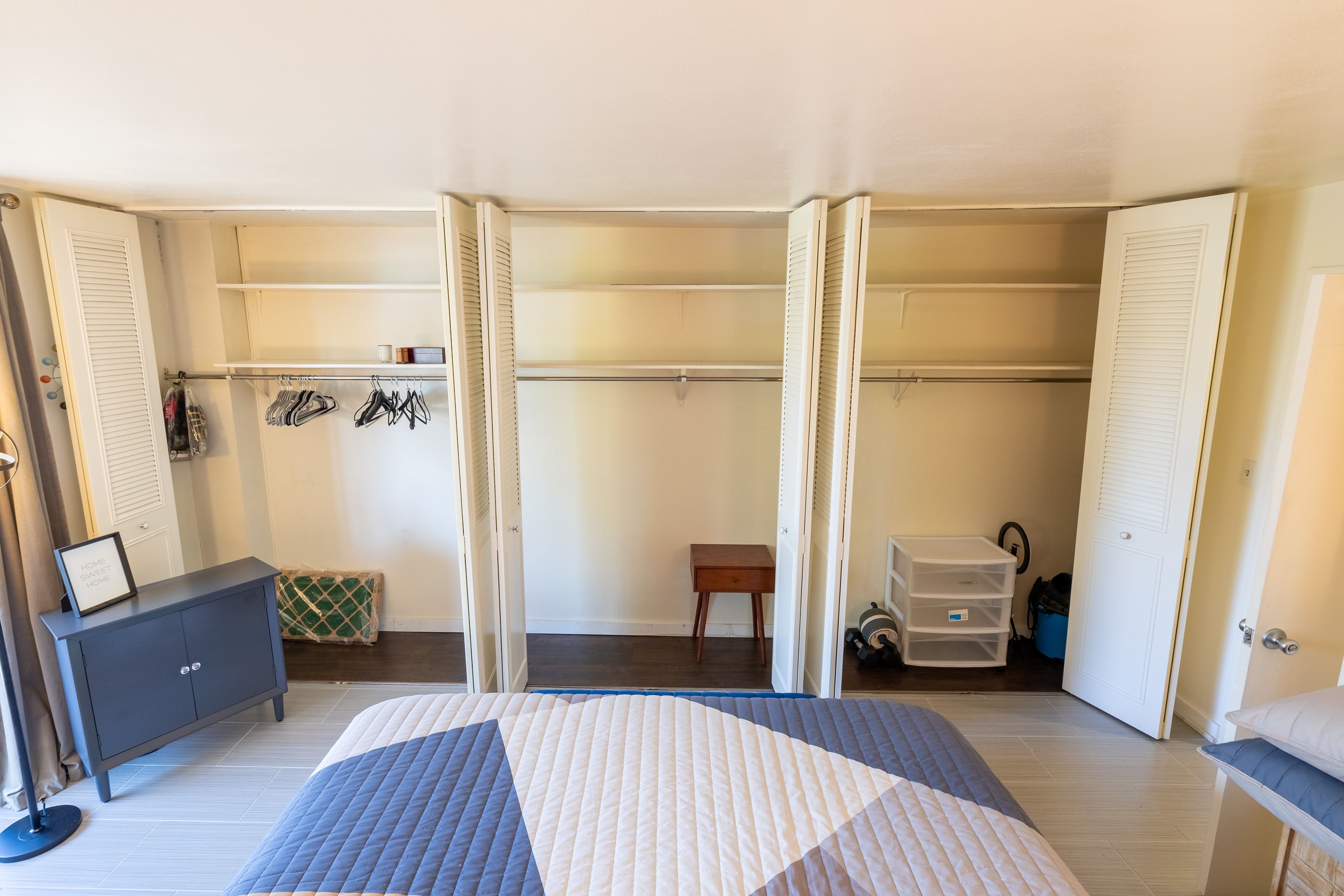 Bedroom featuring light-tone flooring and multiple bi-fold louvered closet doors