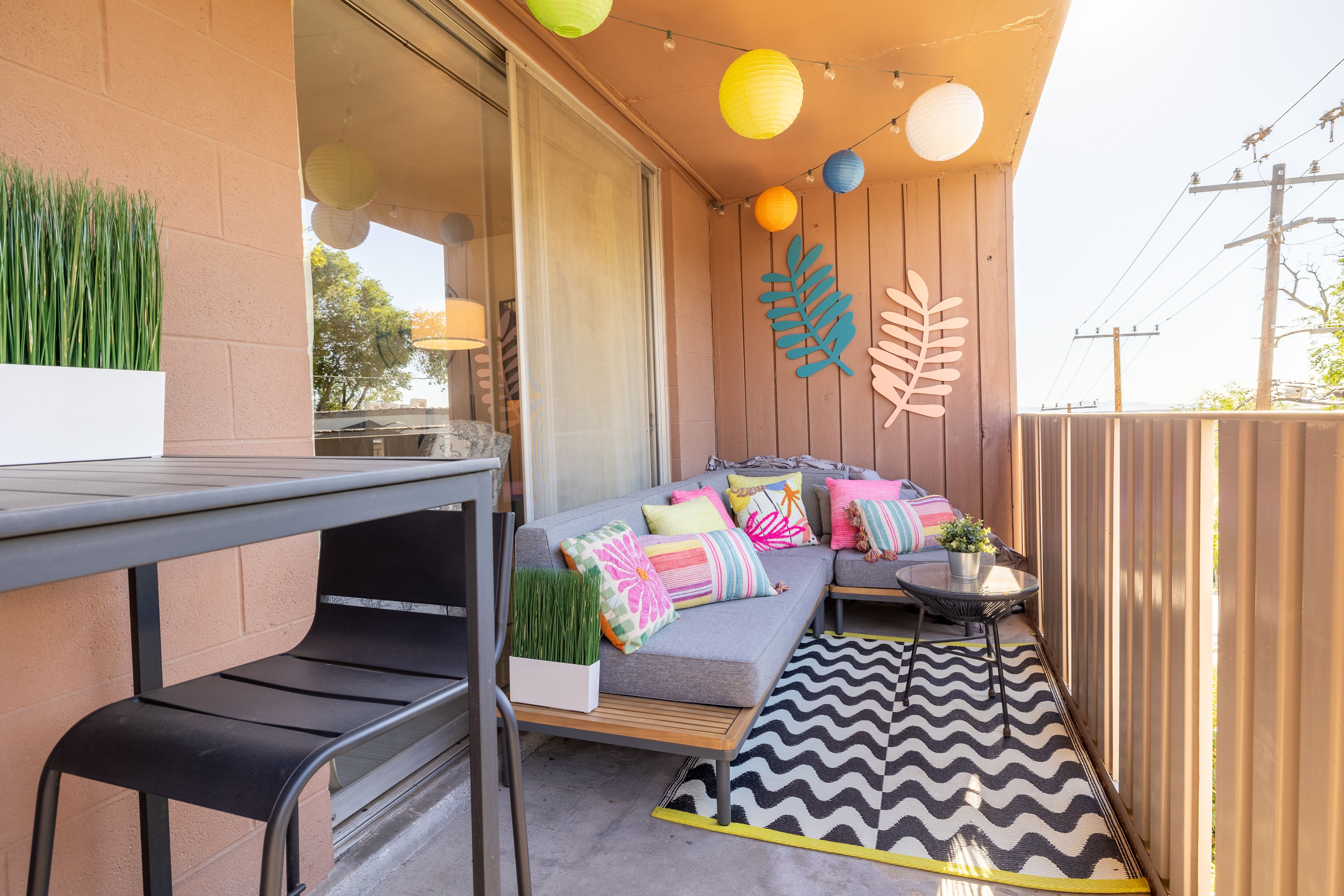 Private balcony featuring a concrete floor, slatted wood paneling, and a full-height sliding glass door