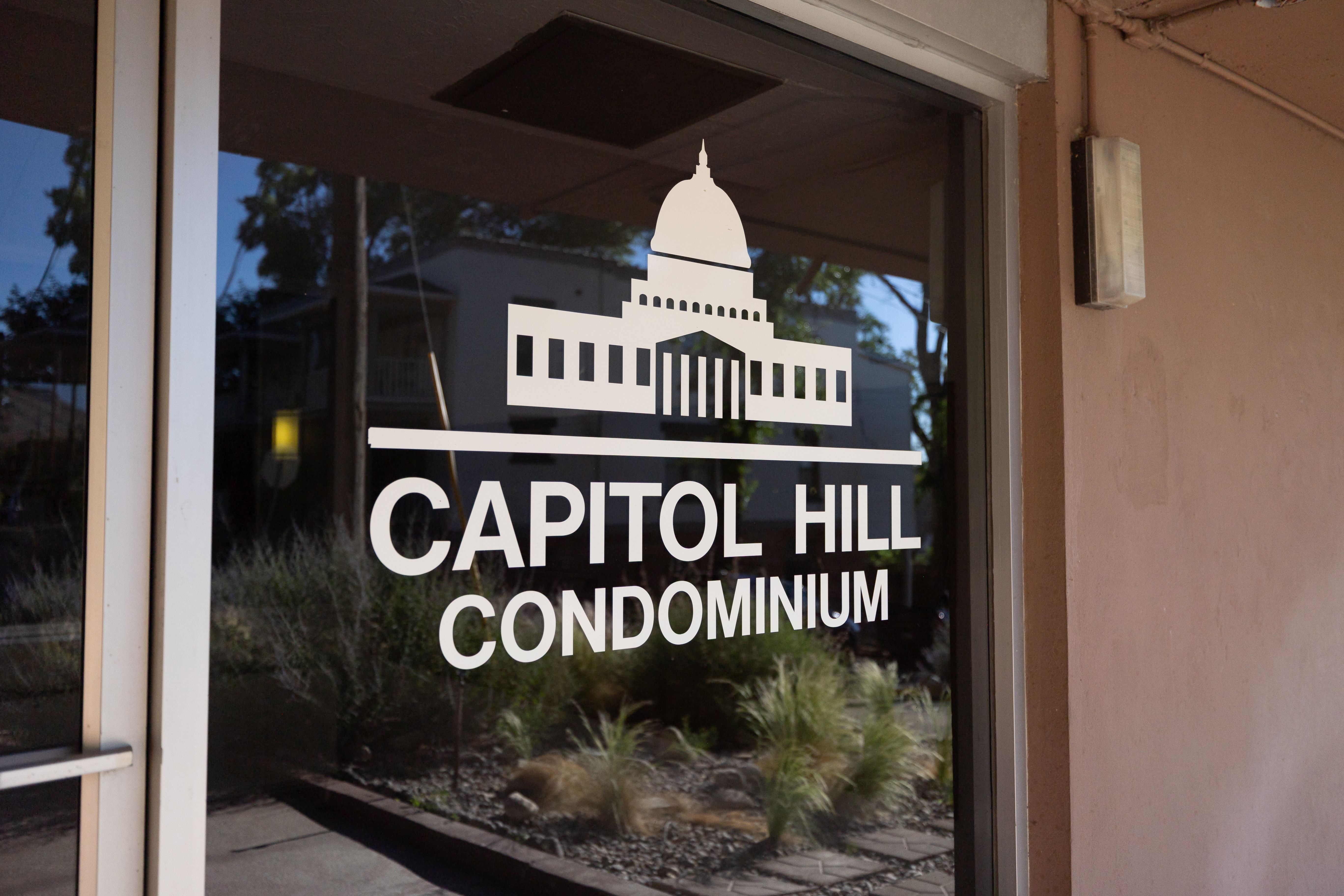 Glass entry door featuring "Capitol Hill Condominium" signage and building logo