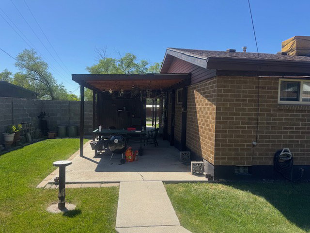 Brick exterior featuring an attached patio cover with wood-finish beams
