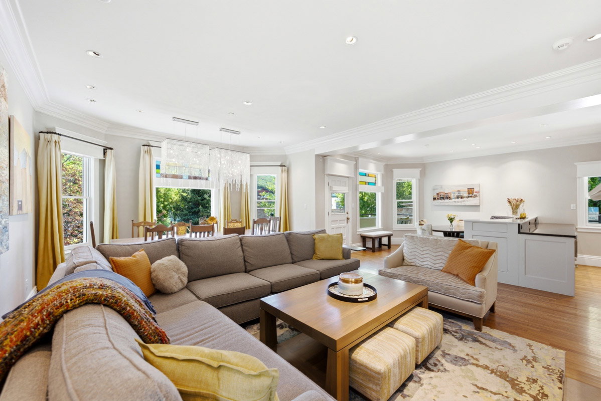 Open-concept living area featuring wood-finish flooring throughout, recessed lighting, and crown molding