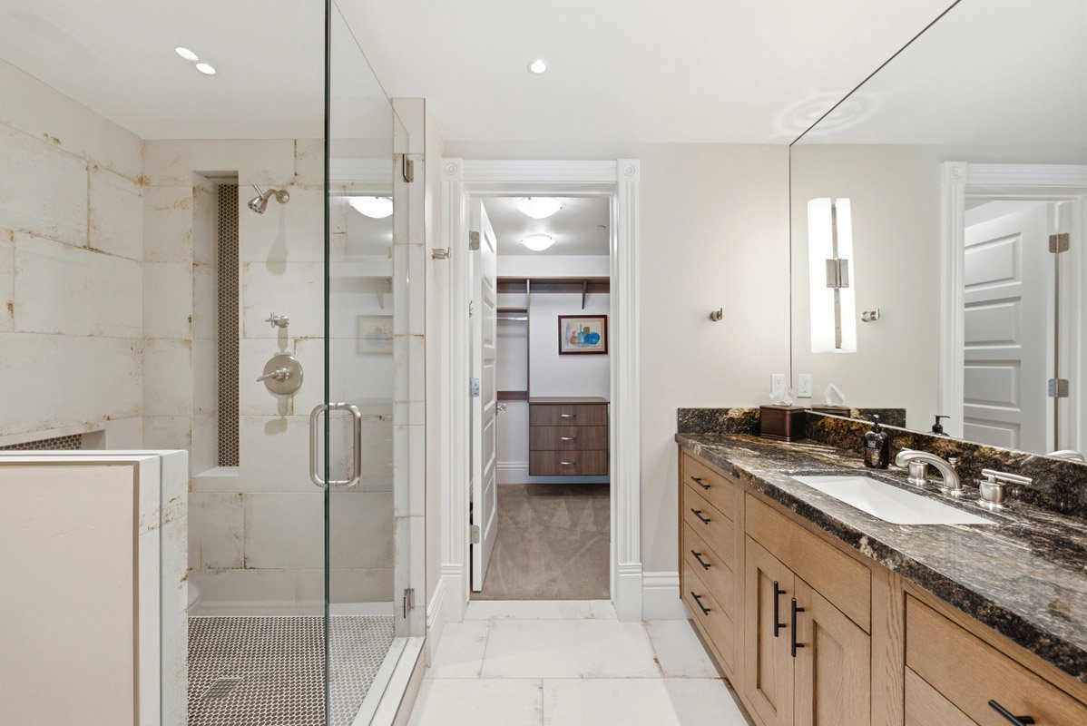 Glass-enclosed shower with tiled walls and a built-in niche